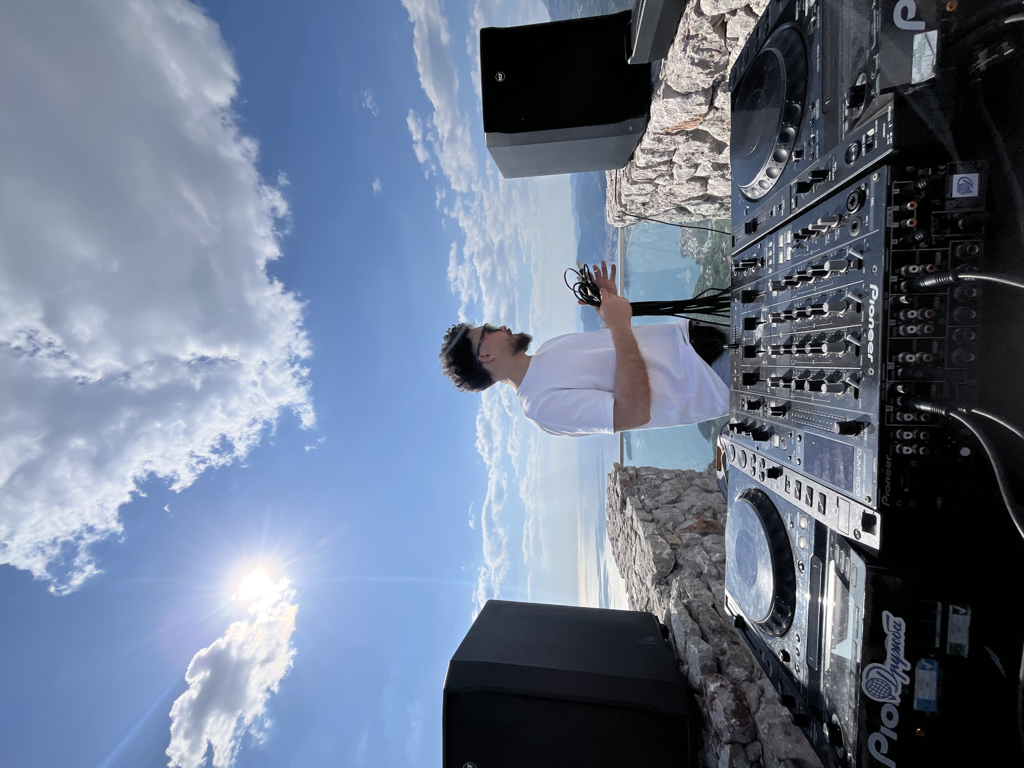 DJ setup documented on Montenegro clifftop overlooking water