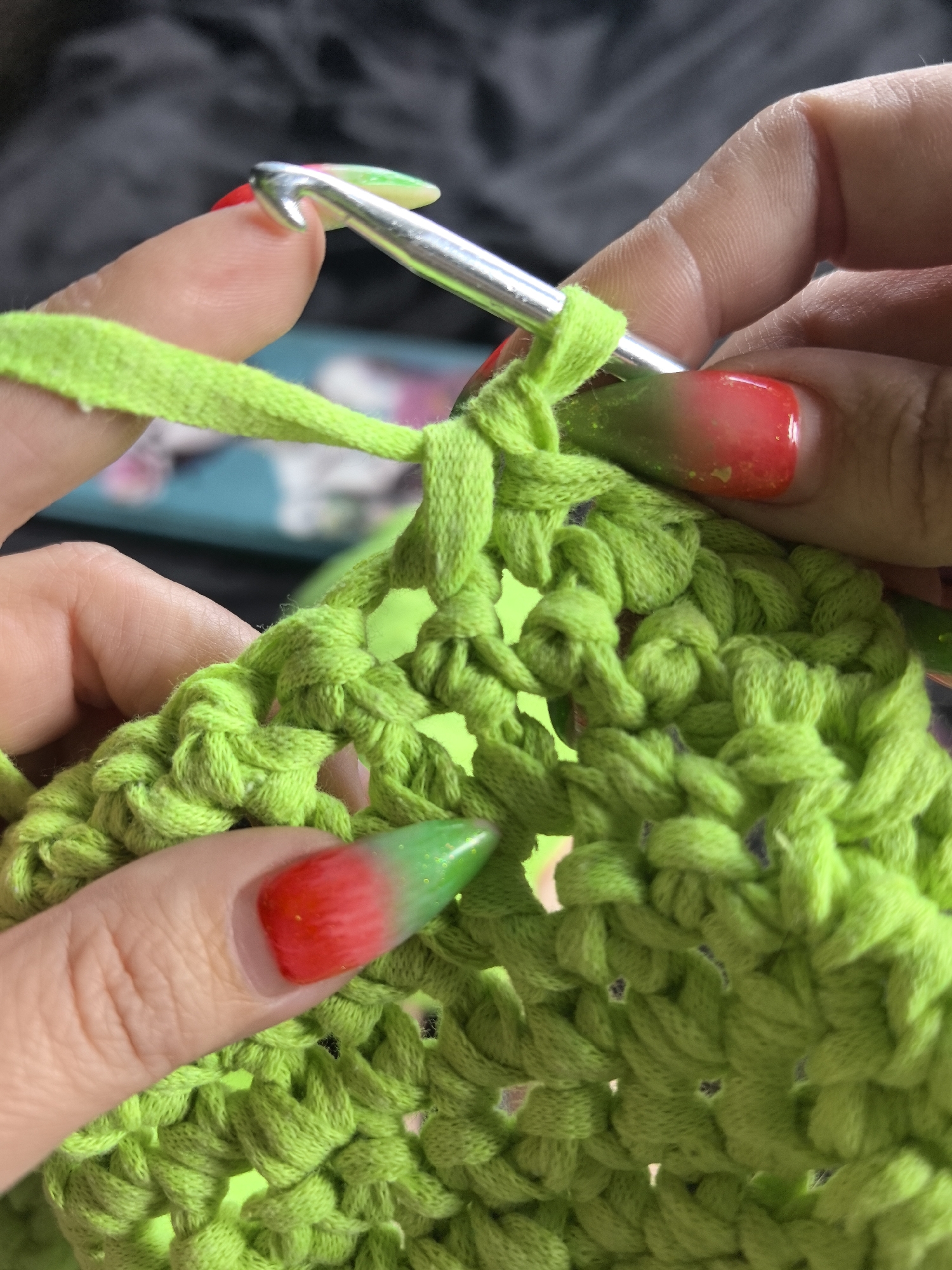 Woman crochets neon green yarn with bulldog companion in Russia