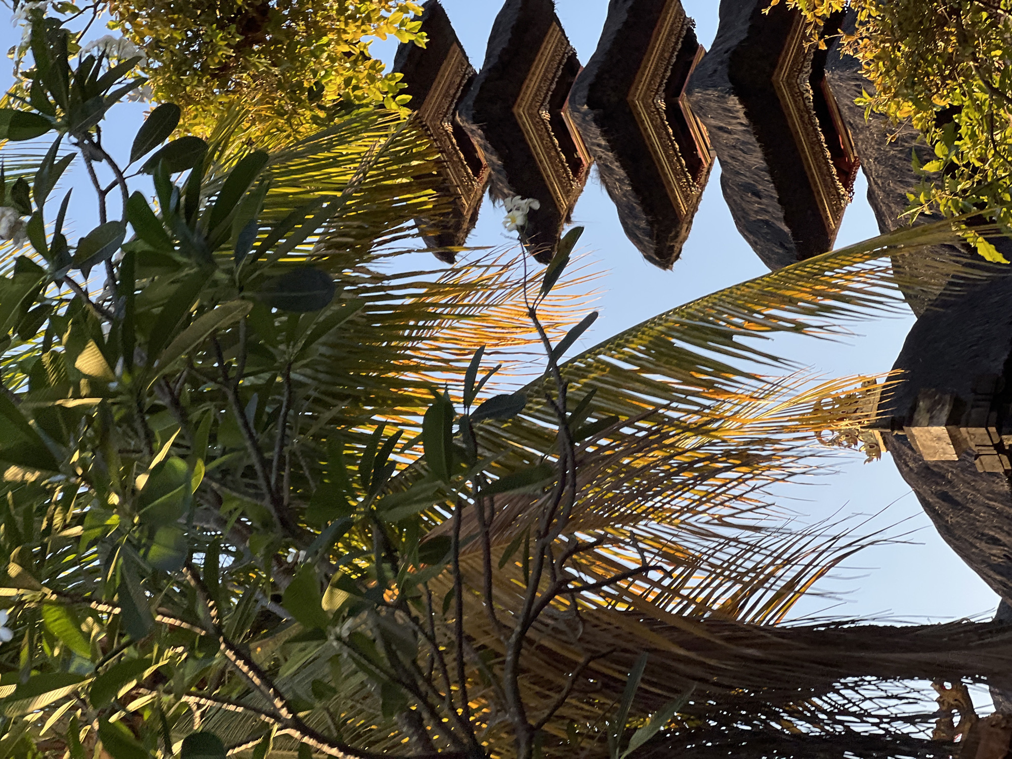 Penjor decorations and a Meru tower along a North Kuta street