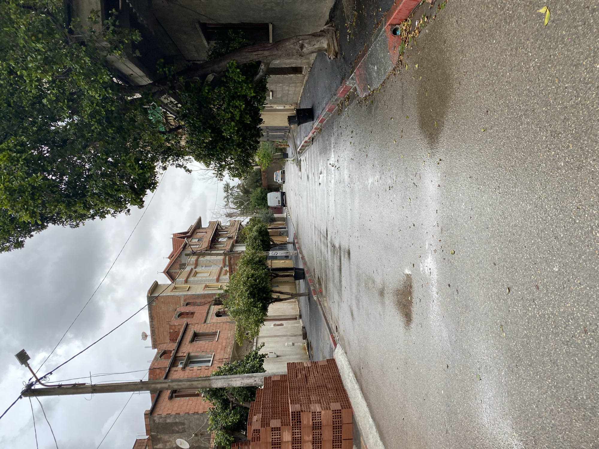 Wet street scene captured in Baraki, Algeria