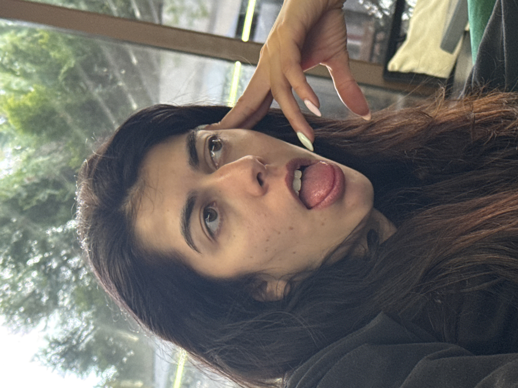 Woman makes playful tongue gesture in Kazanlak, Bulgaria