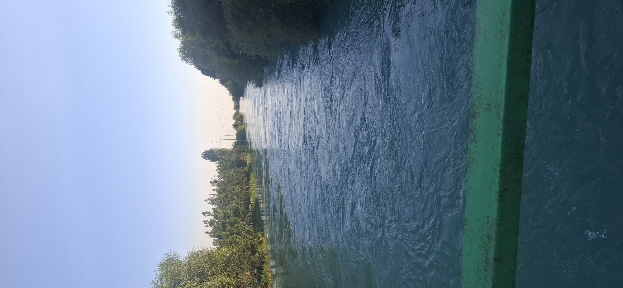 Bridge views over a wide, turquoise river lined with trees