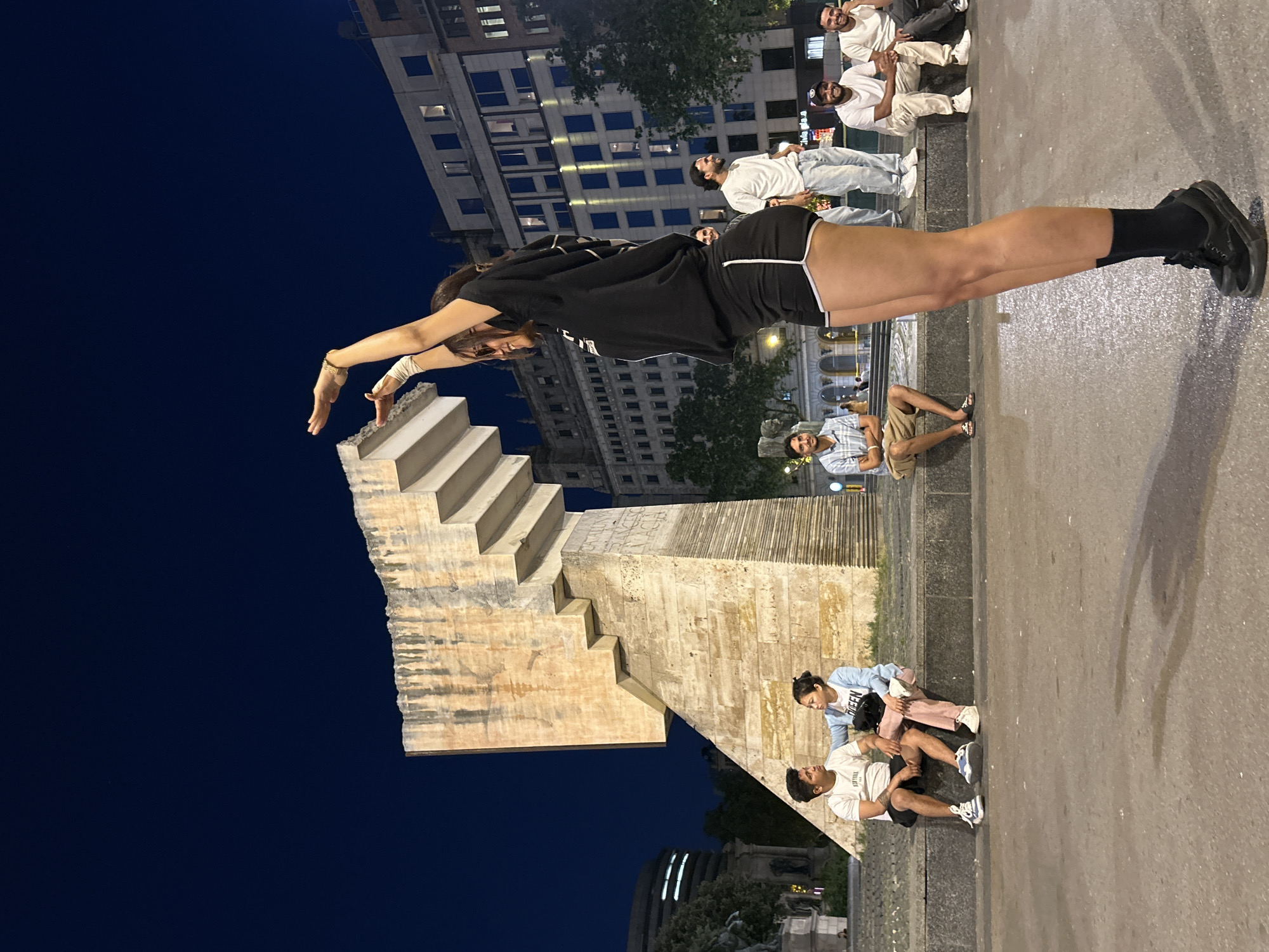 Skateboarder sits by Barcelona fountain during quiet evening