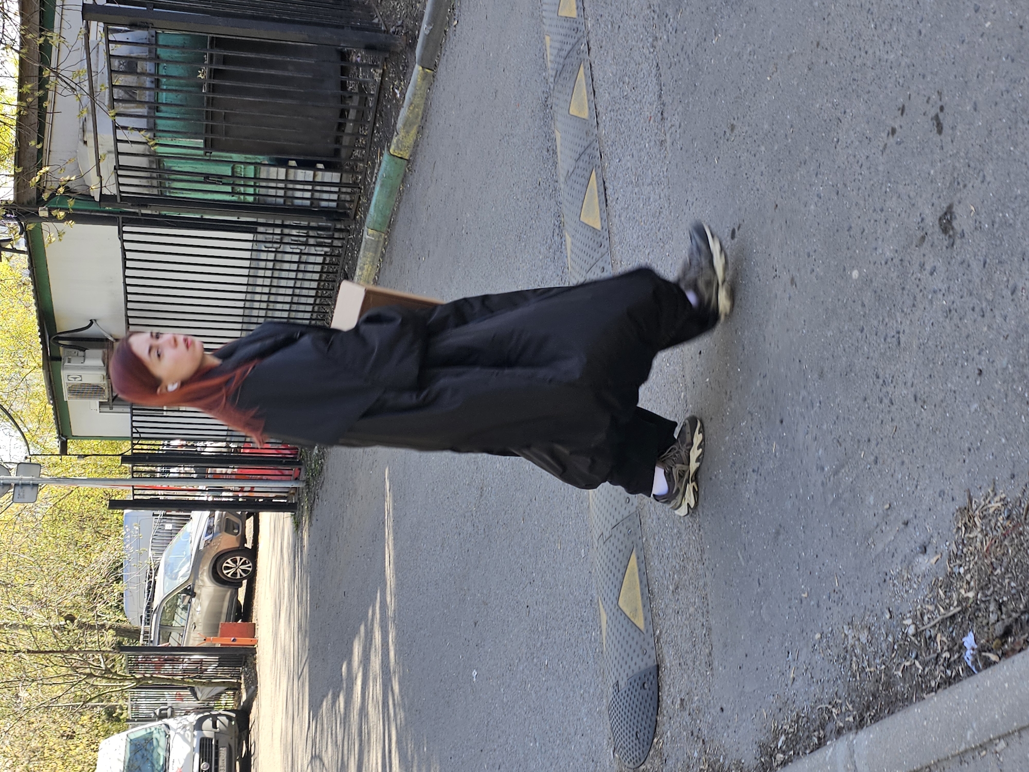 Woman walks Moscow sidewalk near tree stump on sunny day