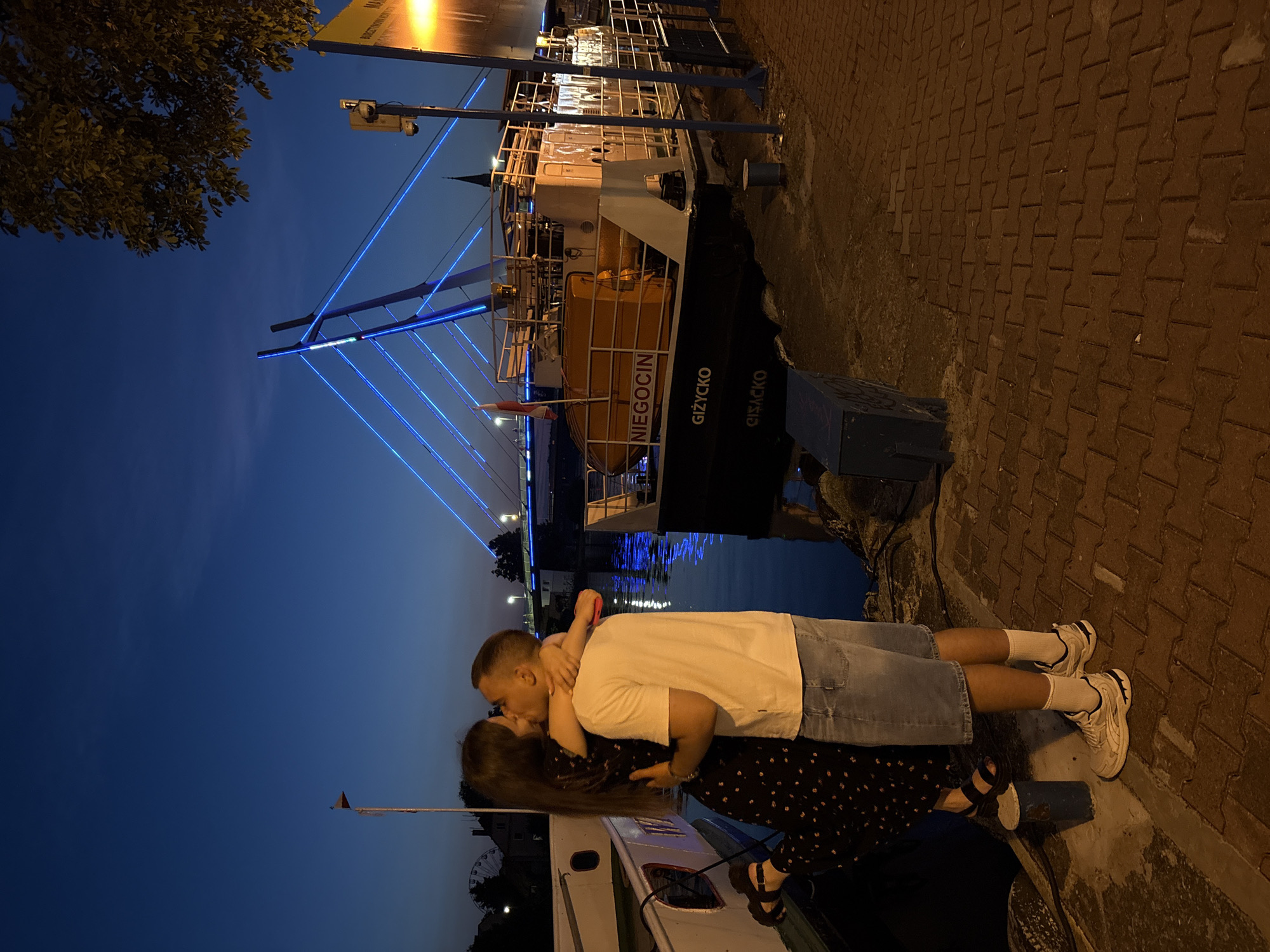 Evening stroll along Mikołajki's waterfront and illuminated suspension bridge