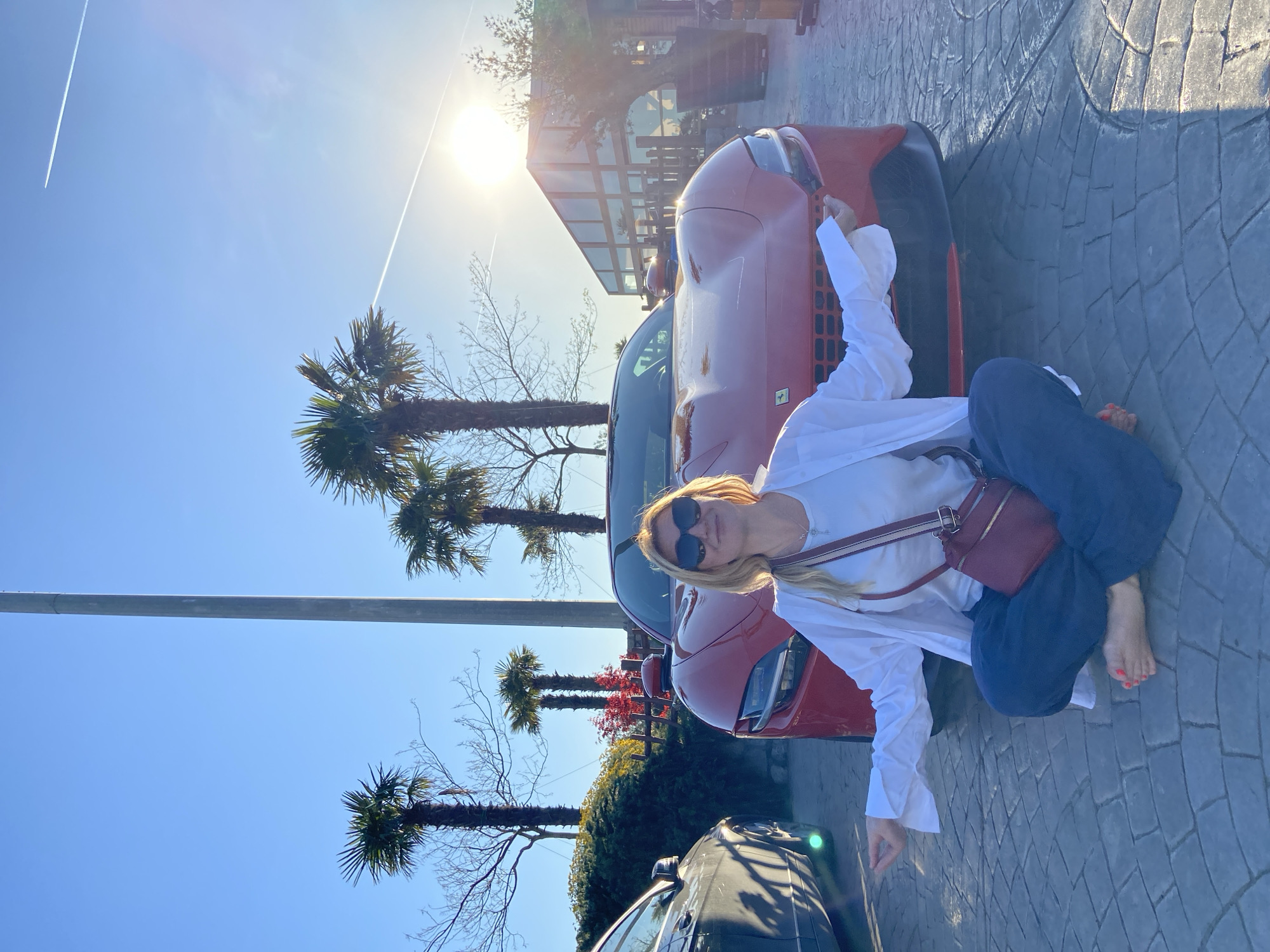 Woman poses with red Ferrari in Montenegro villages