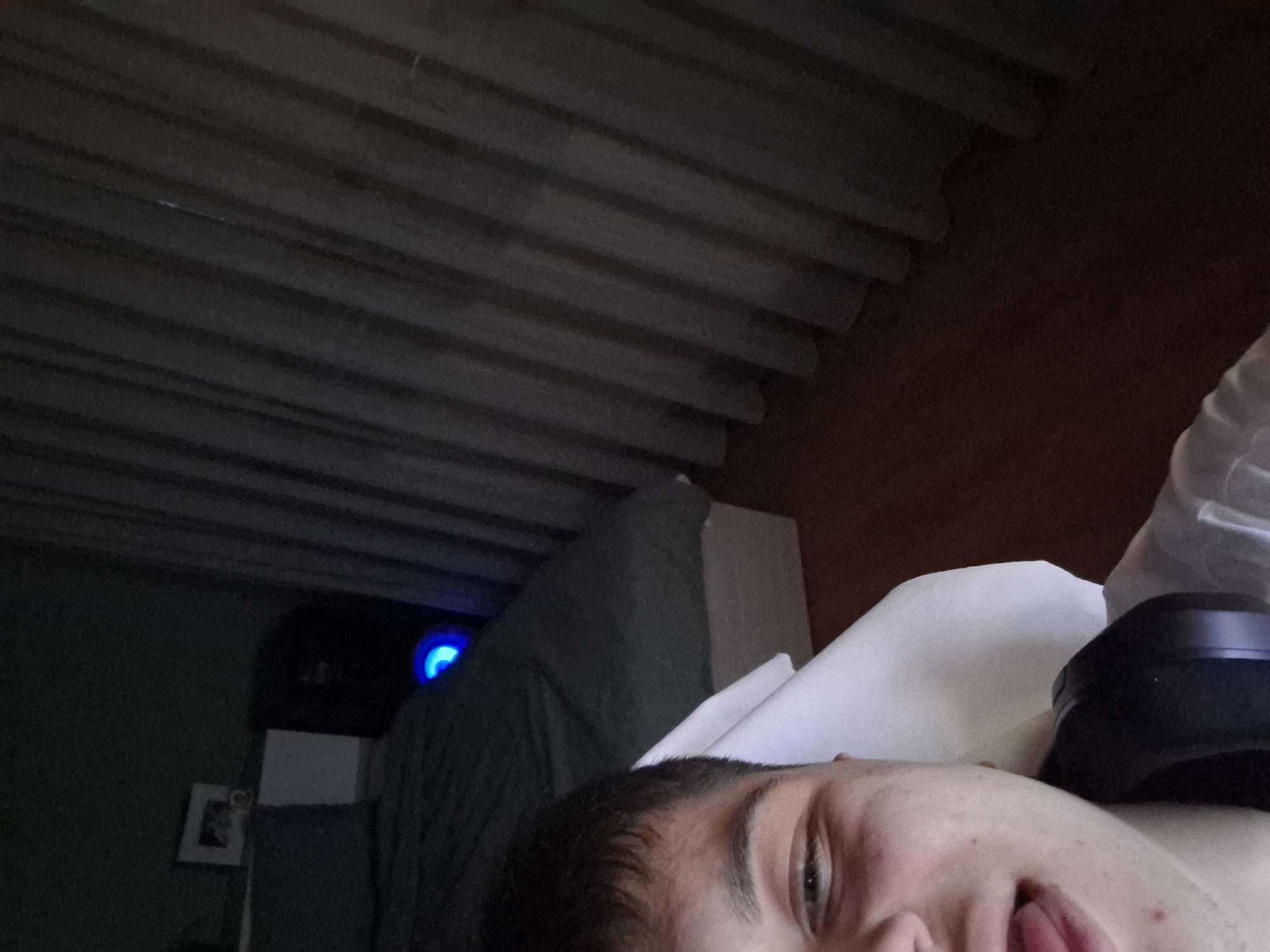 Person resting in bed with headphones in Veliki Preslav
