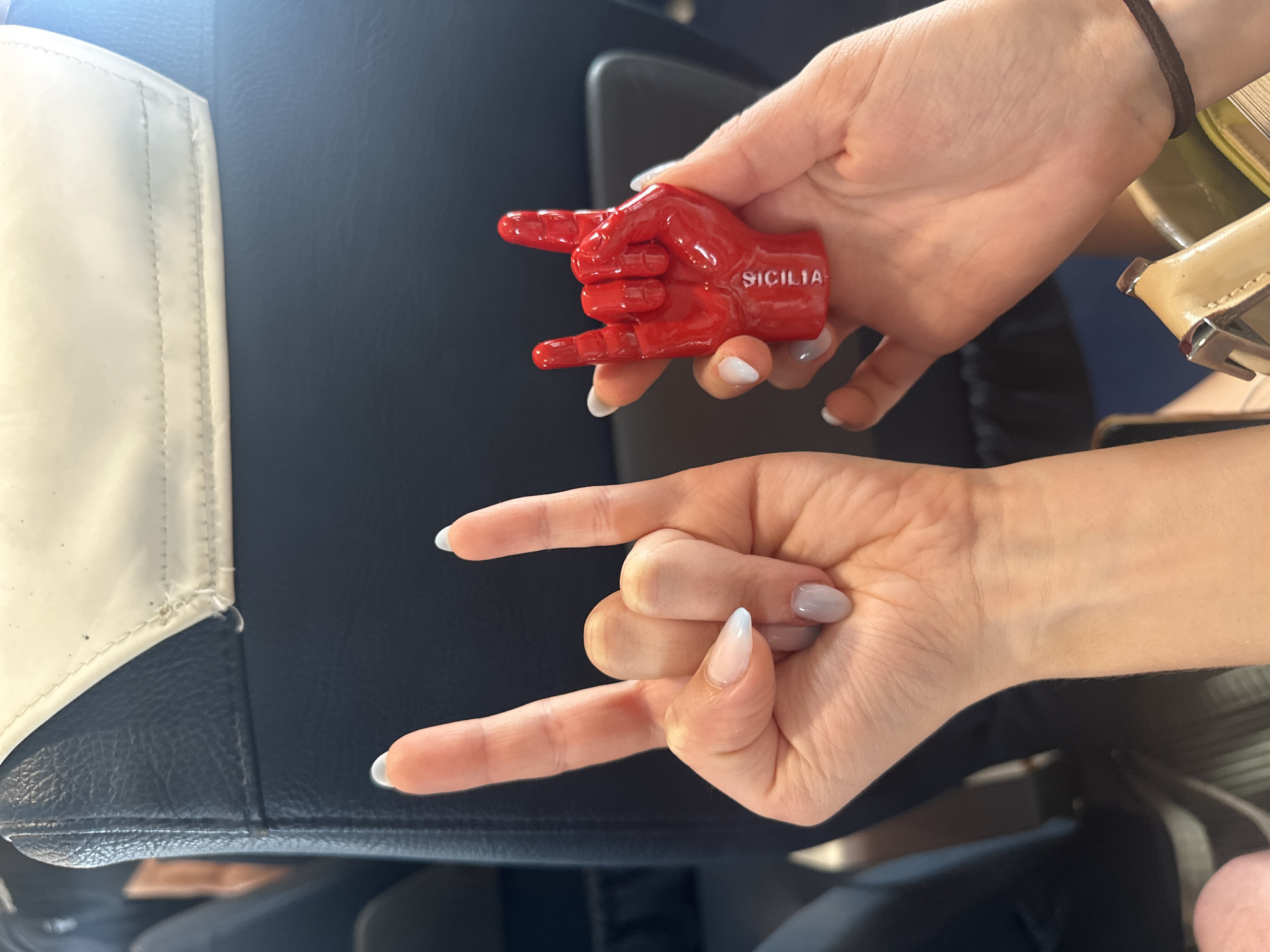 Tourist displays red souvenir with hand gesture in vehicle