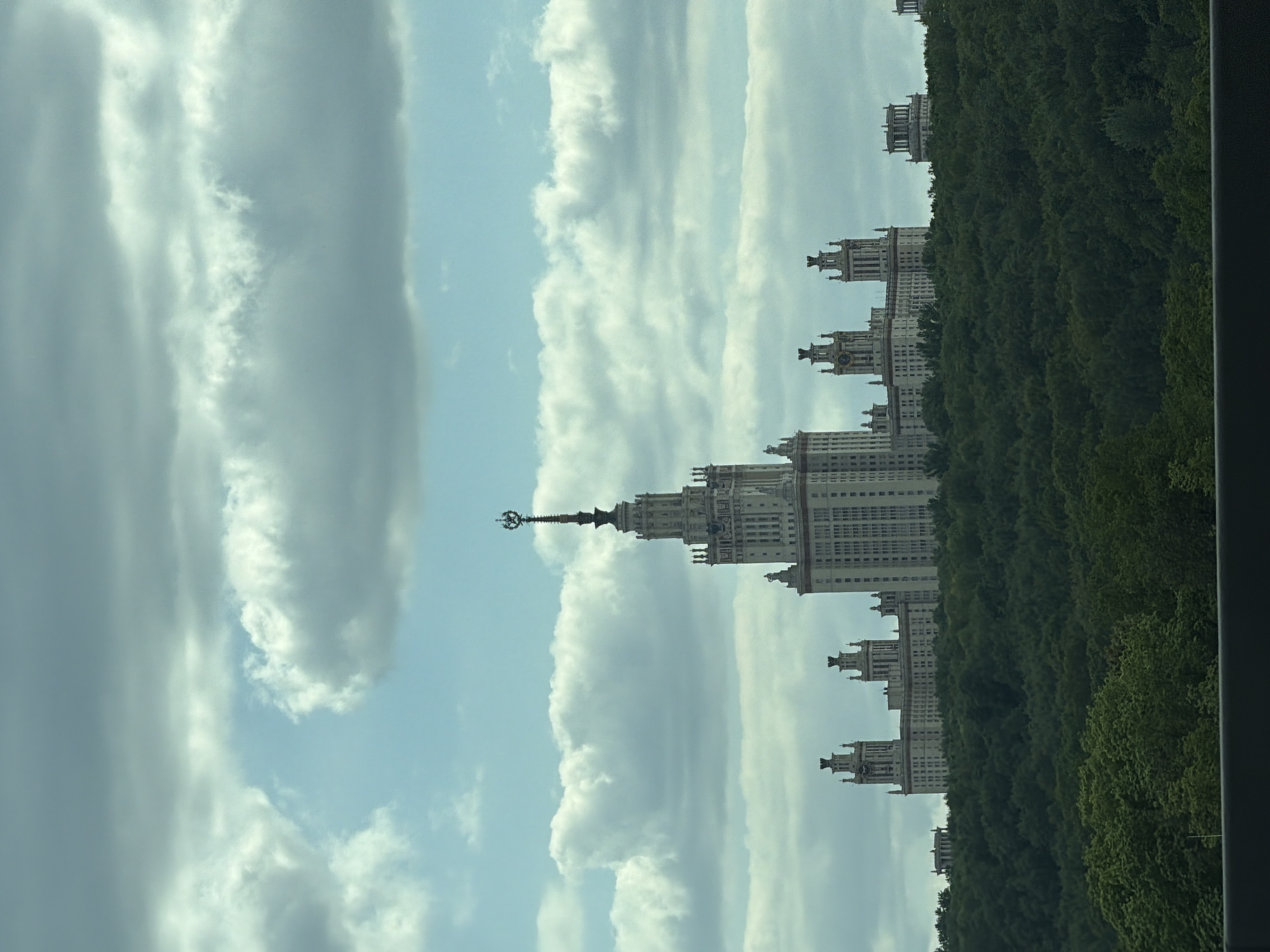 Moscow State University building photographed amid trees and clouds