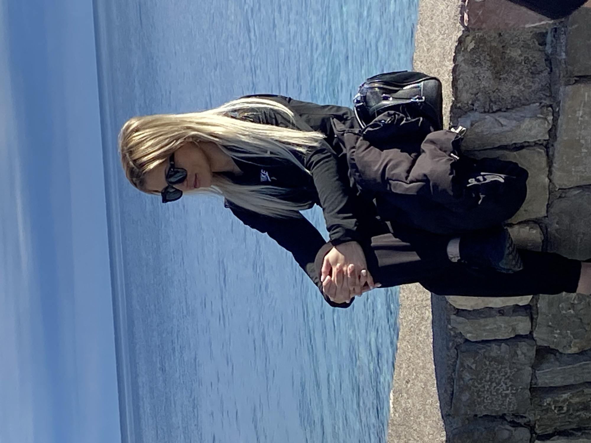 Woman photographed by seaside stone wall in Budva