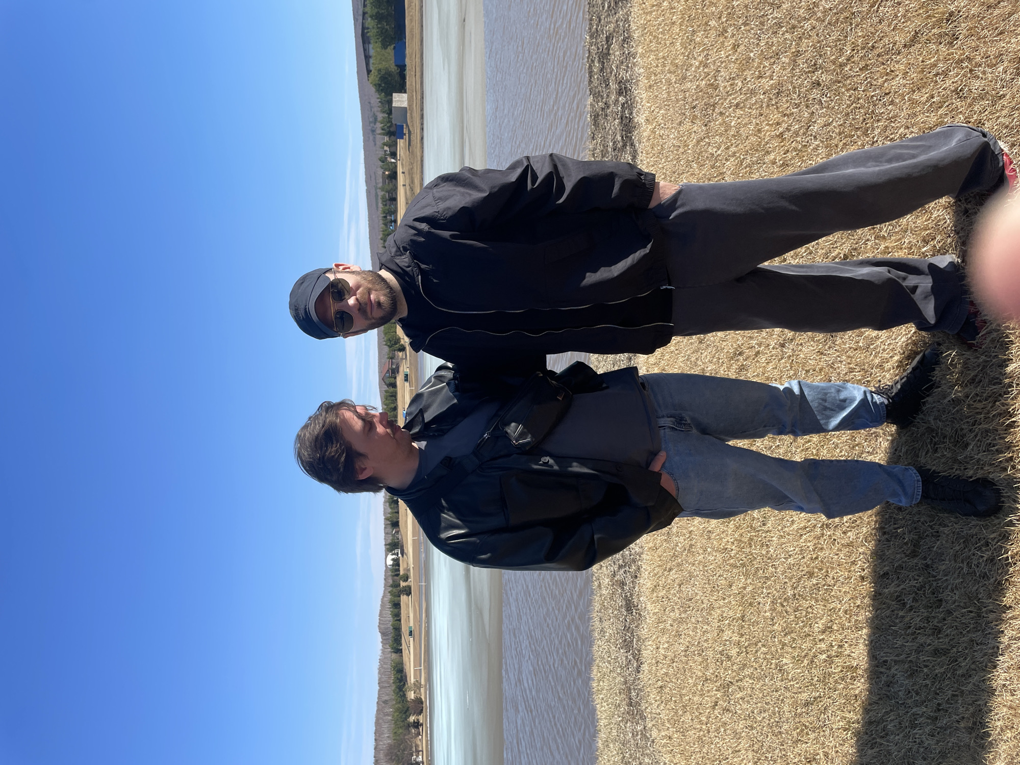 Two men photographed by lake in sunny Emel'yanovo, Russia