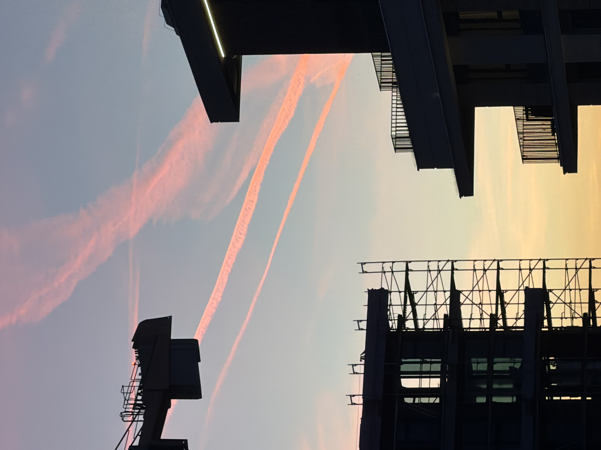 Aircraft contrails spotted over Belgrade buildings during evening hours