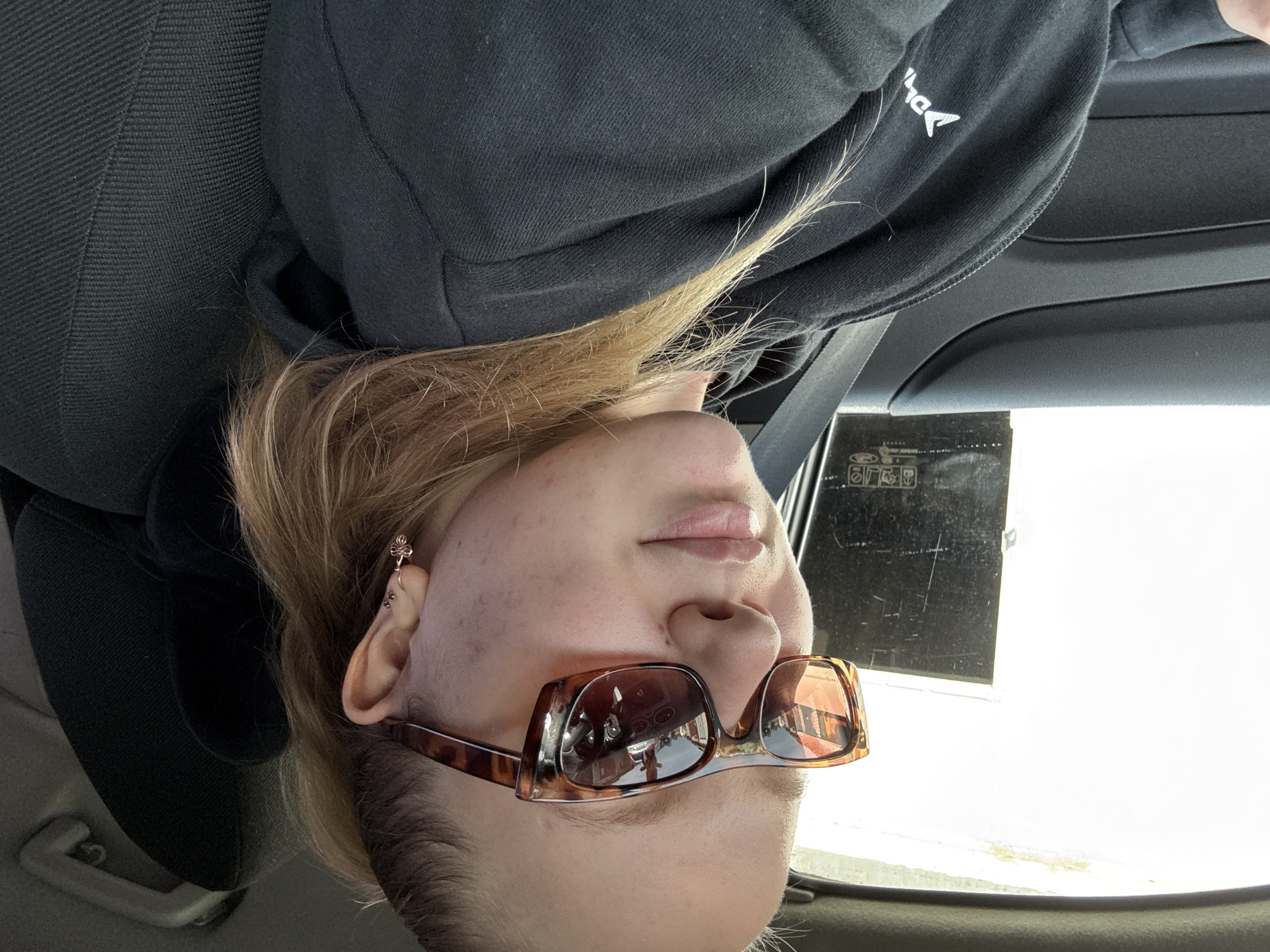 Selfie in a car, Chaikovsky — tortoiseshell shades and flower earring