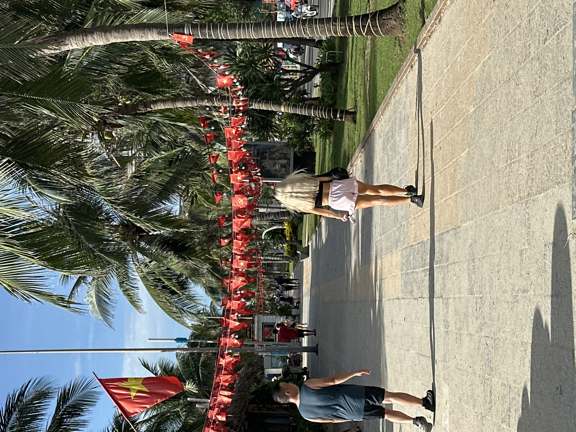 Morning activity on Đà Nẵng's flag-decorated beachfront promenade