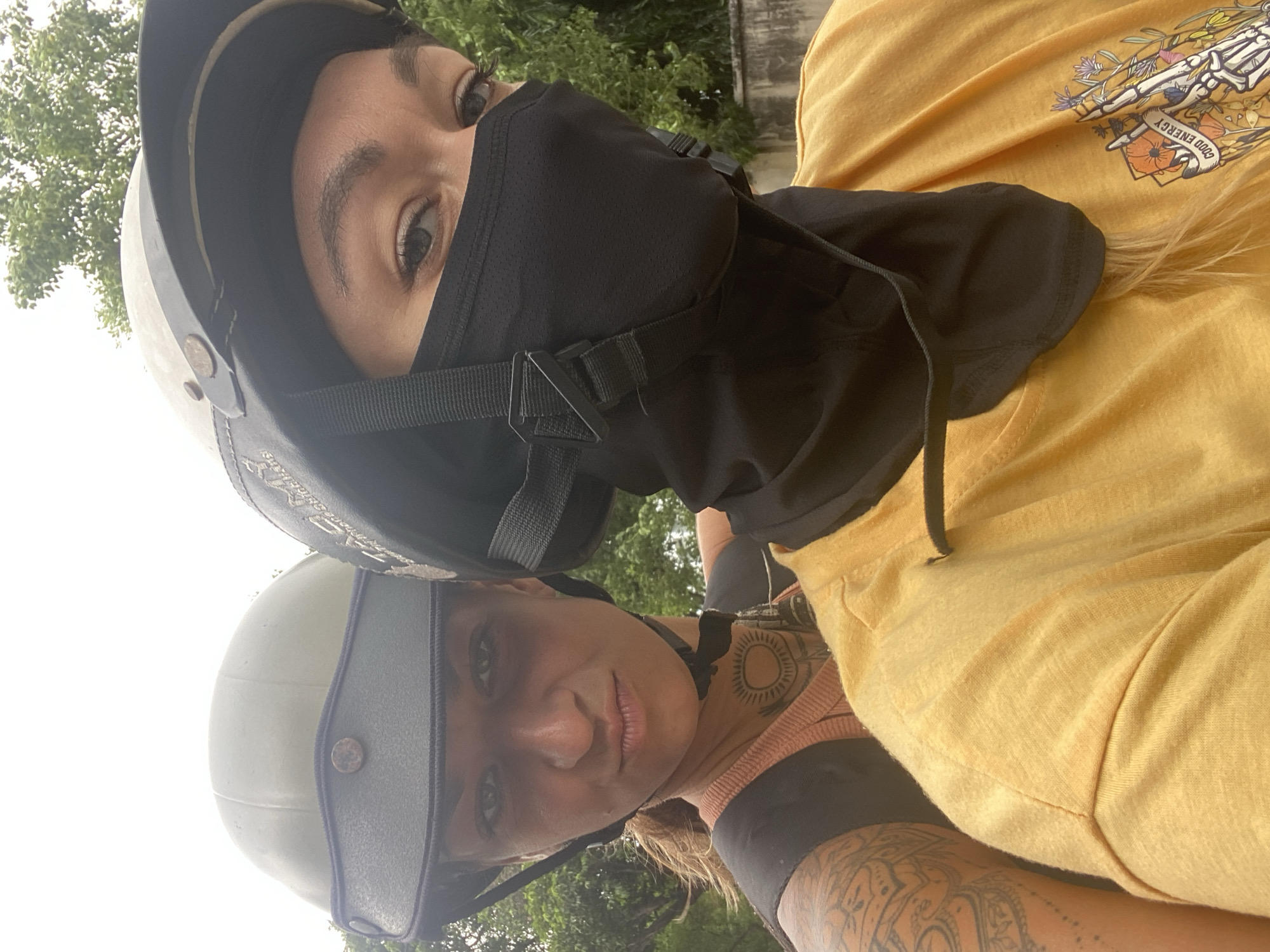 Two helmeted women take motorcycle selfie in Vietnam