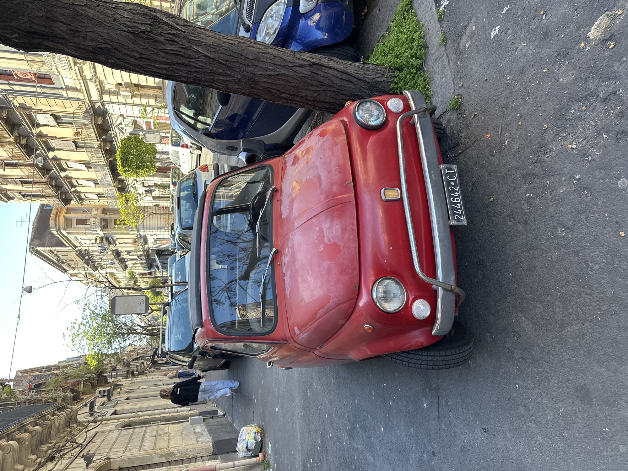 Red Fiat spotted on narrow Catania street amid historic architecture