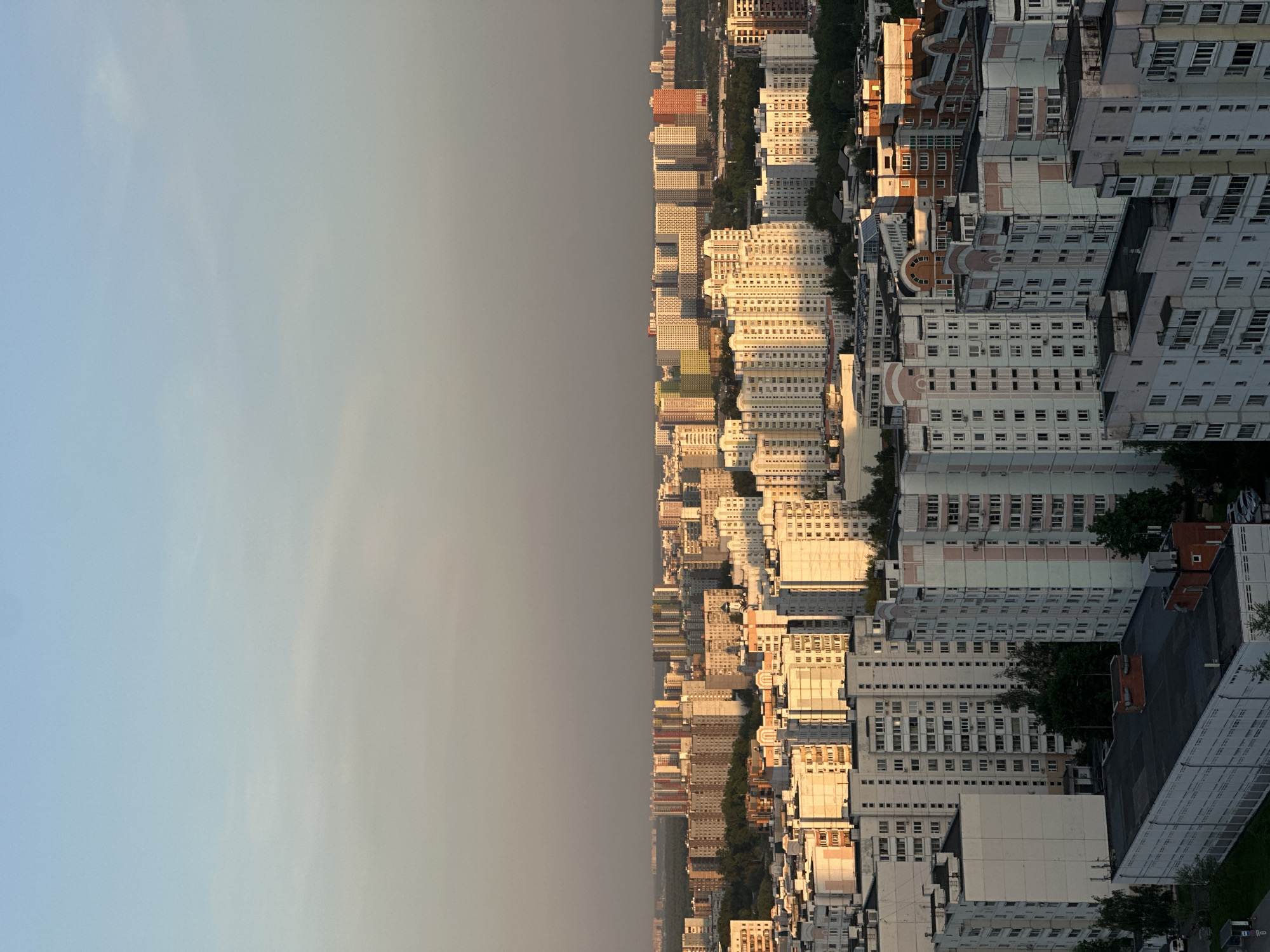 Aerial views capture urban-forest transition under hazy skies