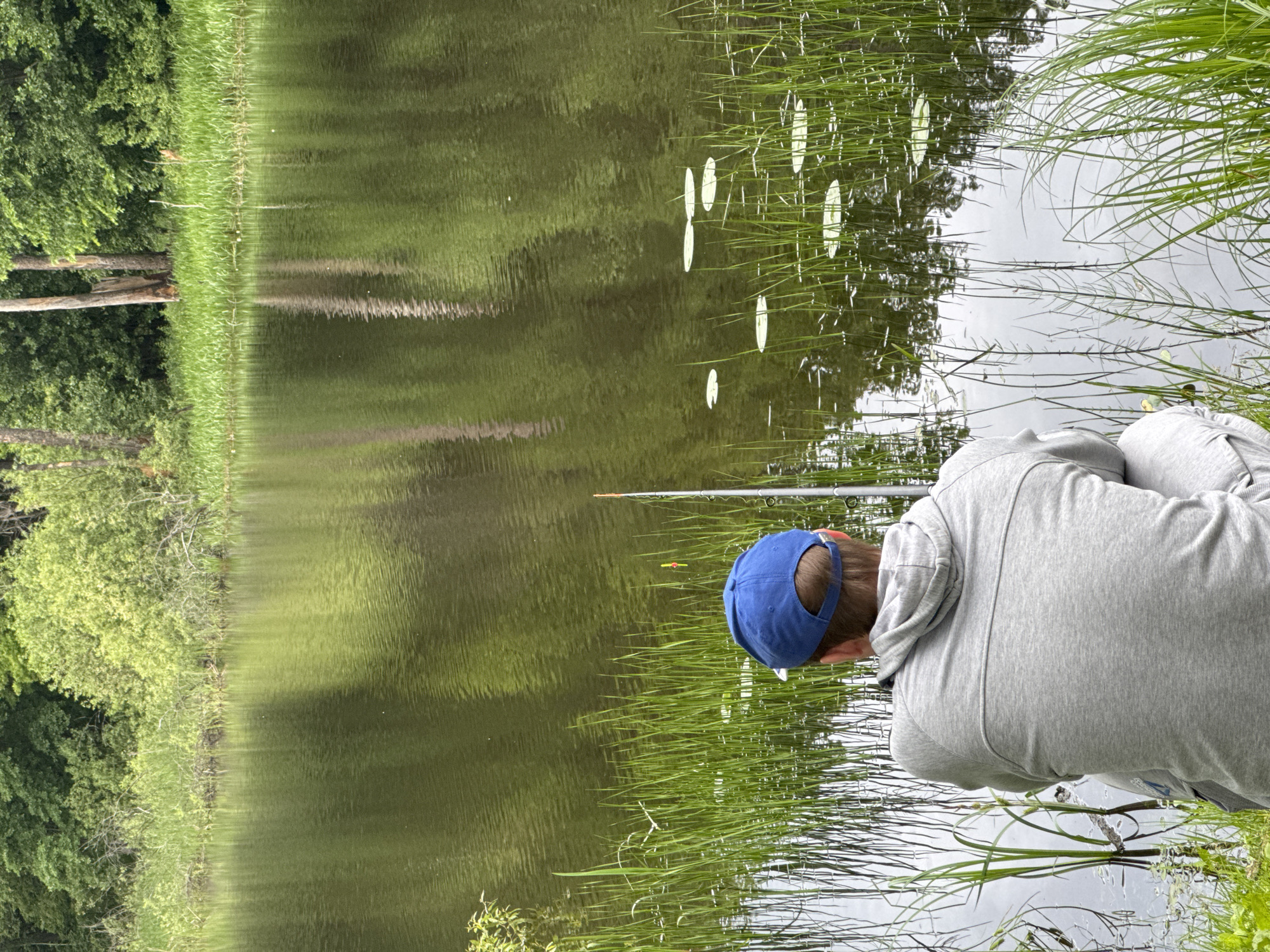 Man fishing at water's edge in Noviy, Russia