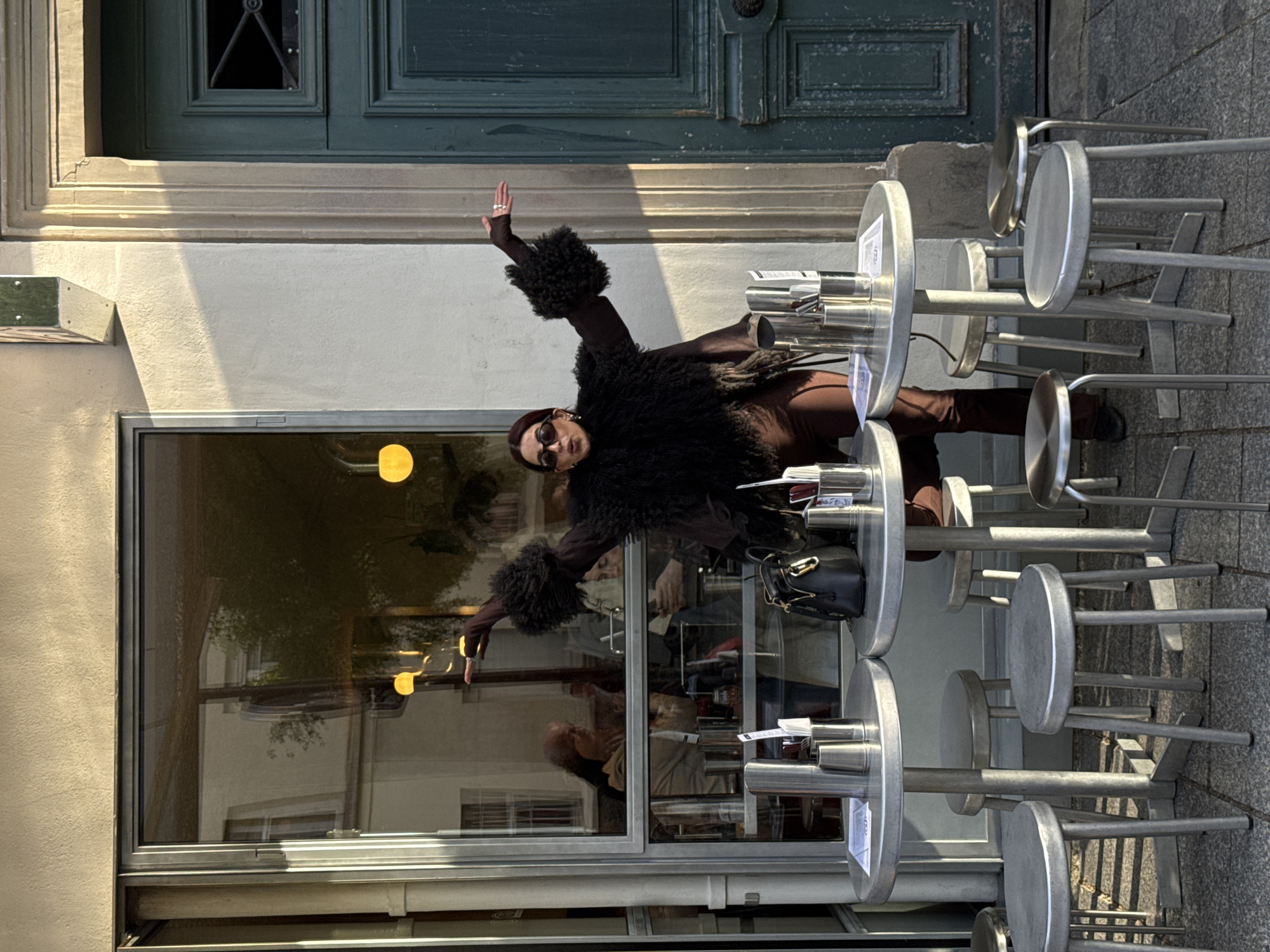 Woman poses outside Paris building in feathered jacket