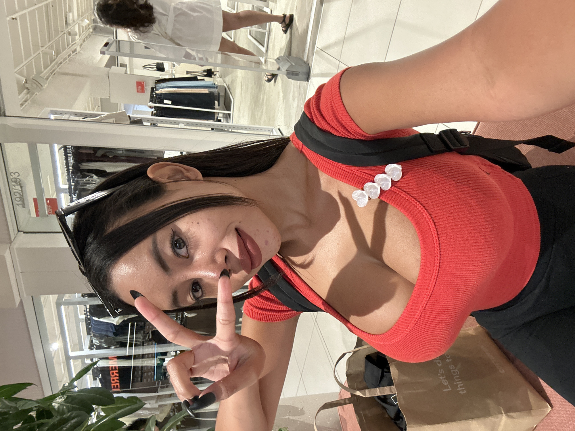 Woman takes peace sign selfie in Sydney clothing store