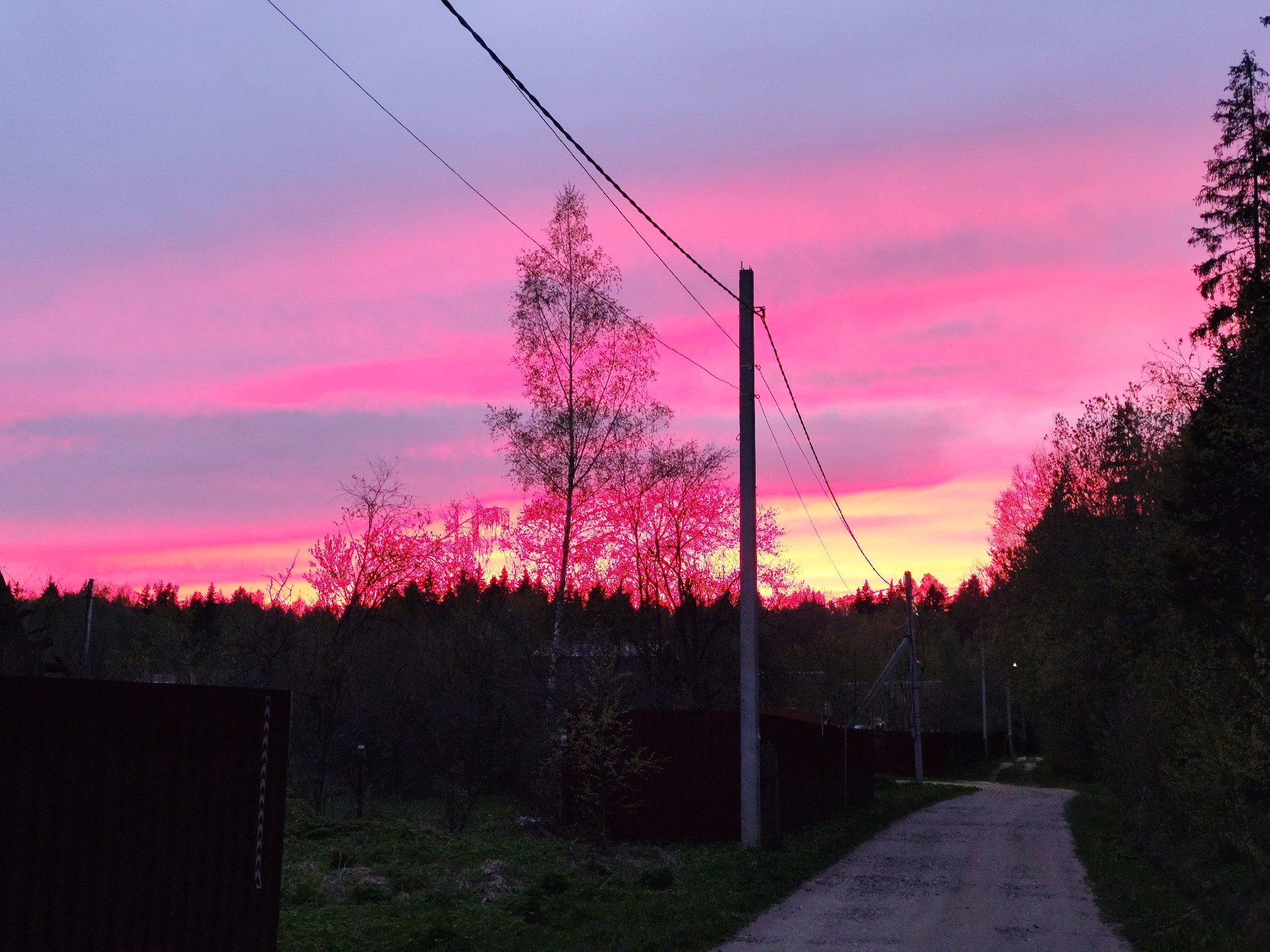 Witness reports vibrant pink sky over rural area