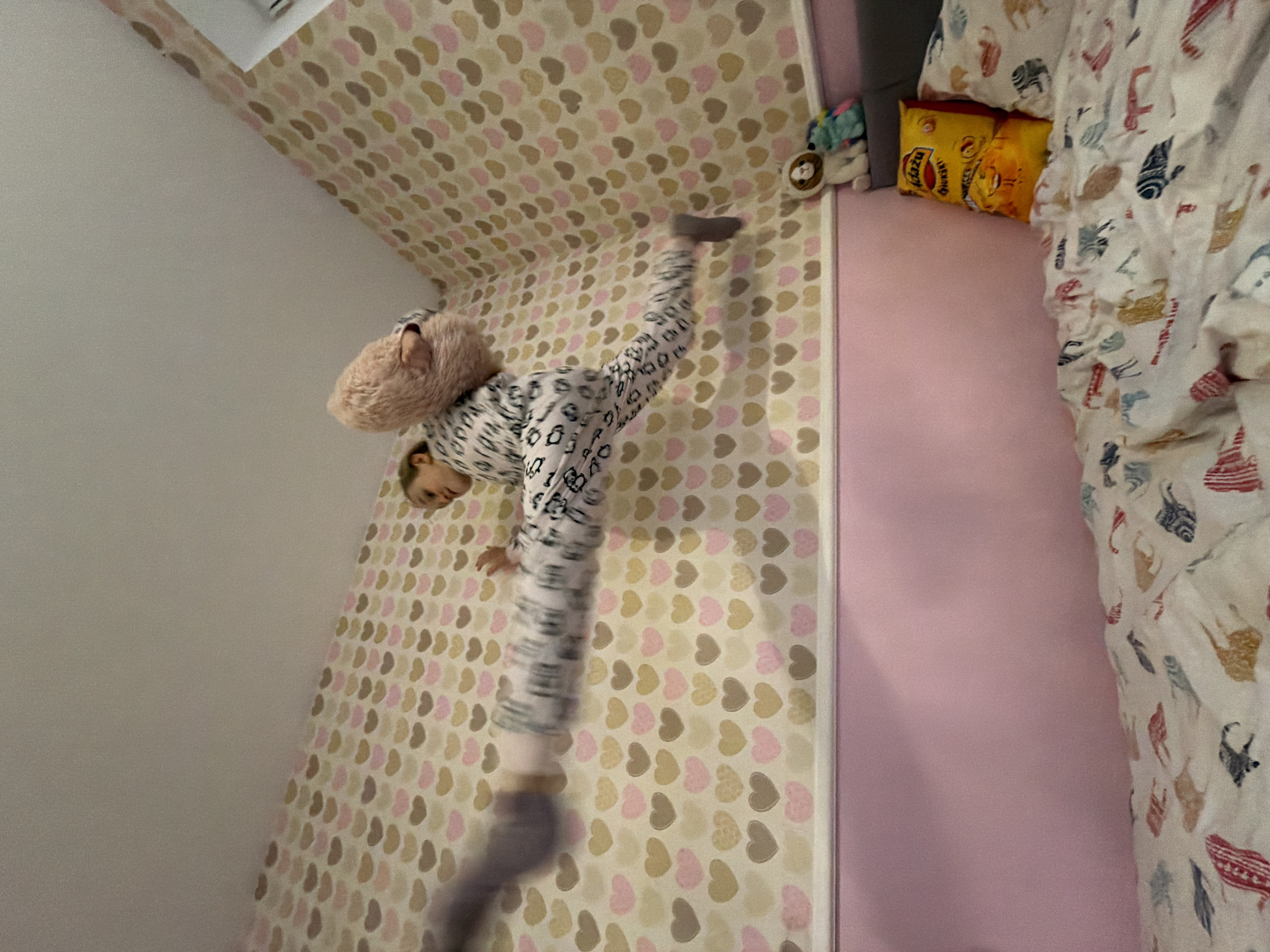 Child practices gymnastics moves in bedroom in Latvia