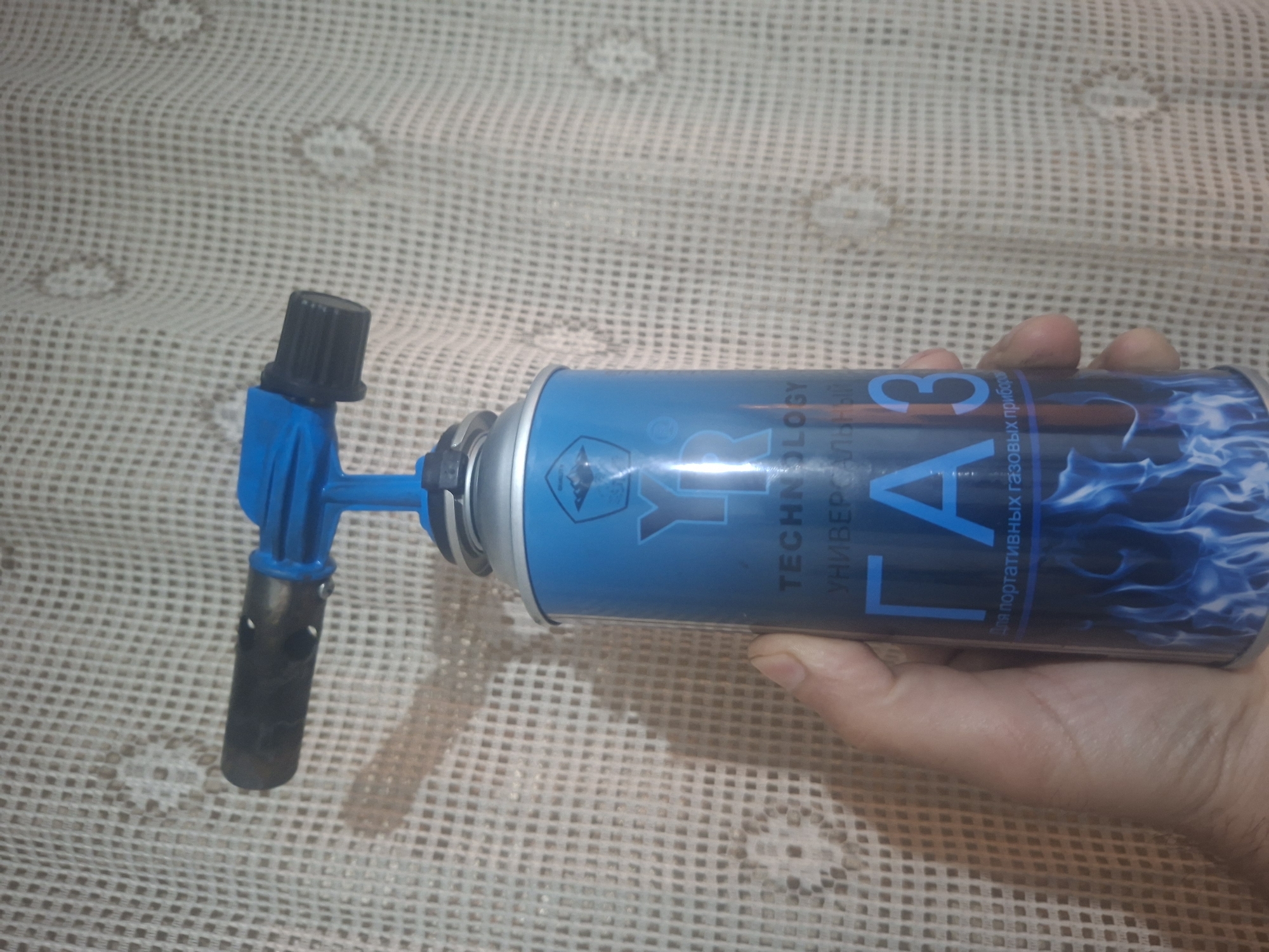 Person displays household items including gas canister, tea, coffee