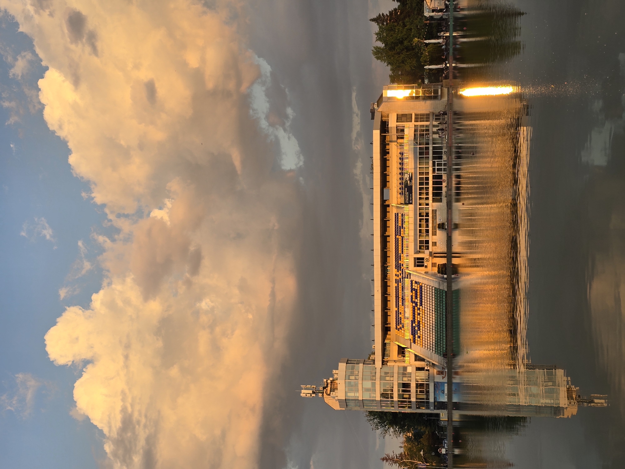 Lakeside building reflections and fish schools observed during sunset