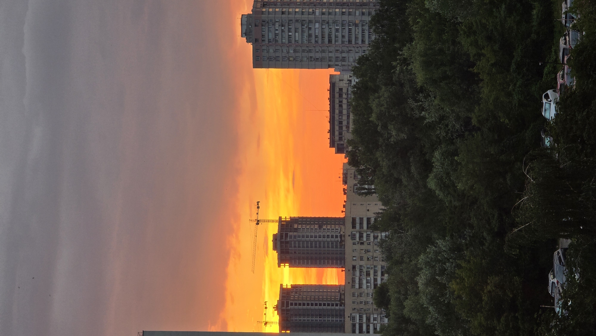 Kyiv sunset frames unfinished high-rises in orange light