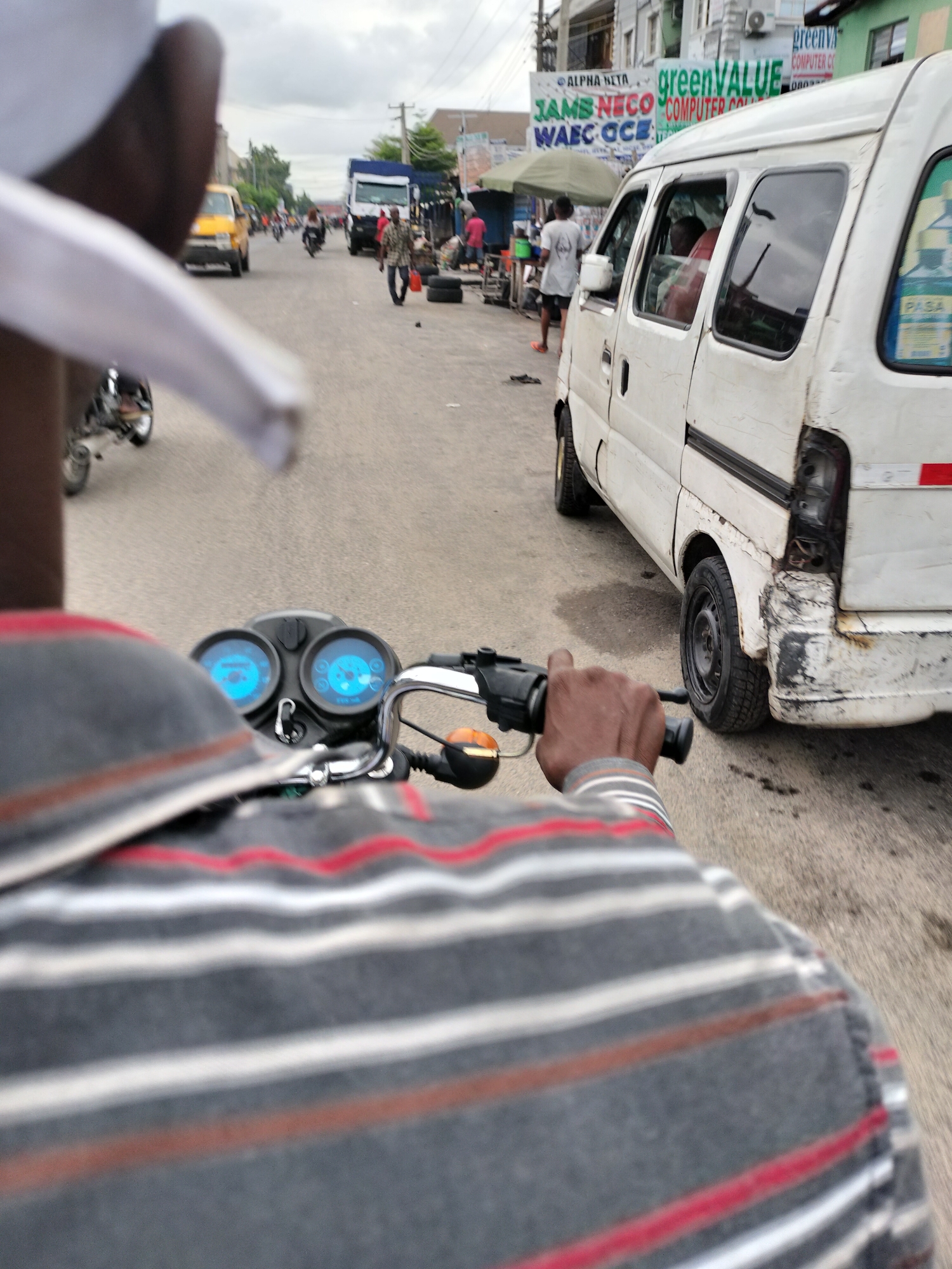 Motorcycle rider travels through busy Alaiyabiagba streets