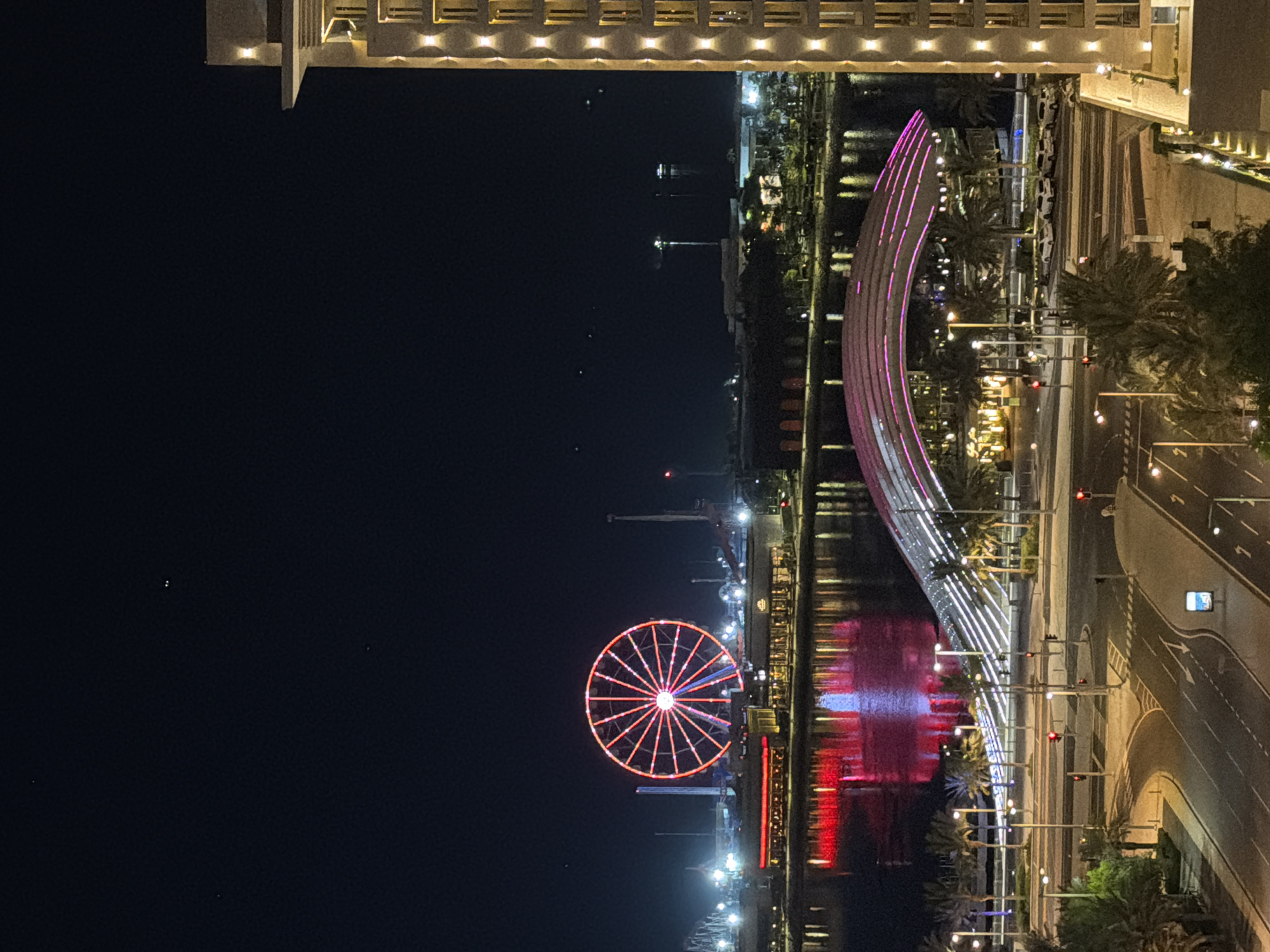Red-lit Ferris wheel glows over Lusail's waterfront at night
