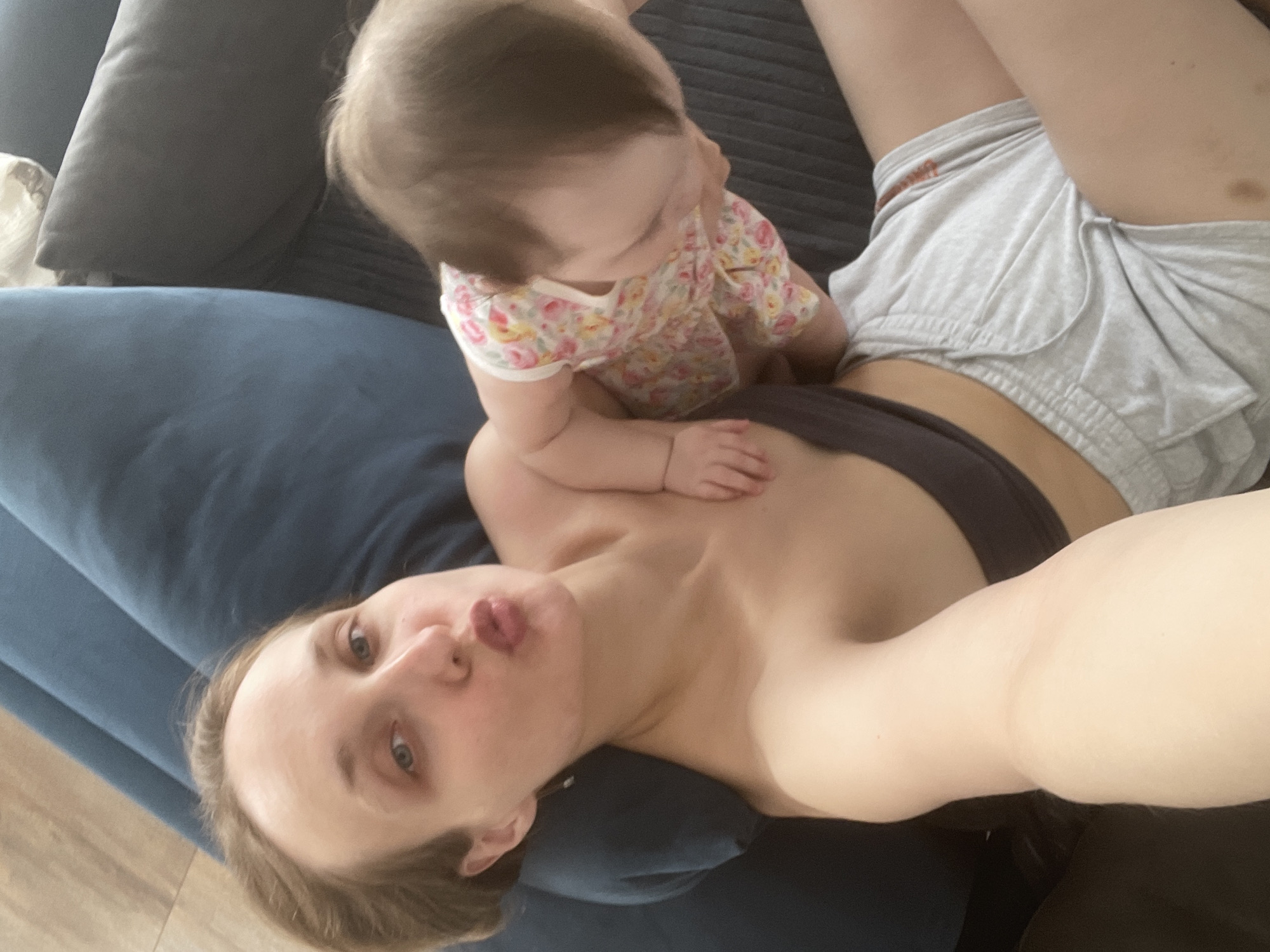 Mother and baby share tender moment on sofa in Podshivalovo
