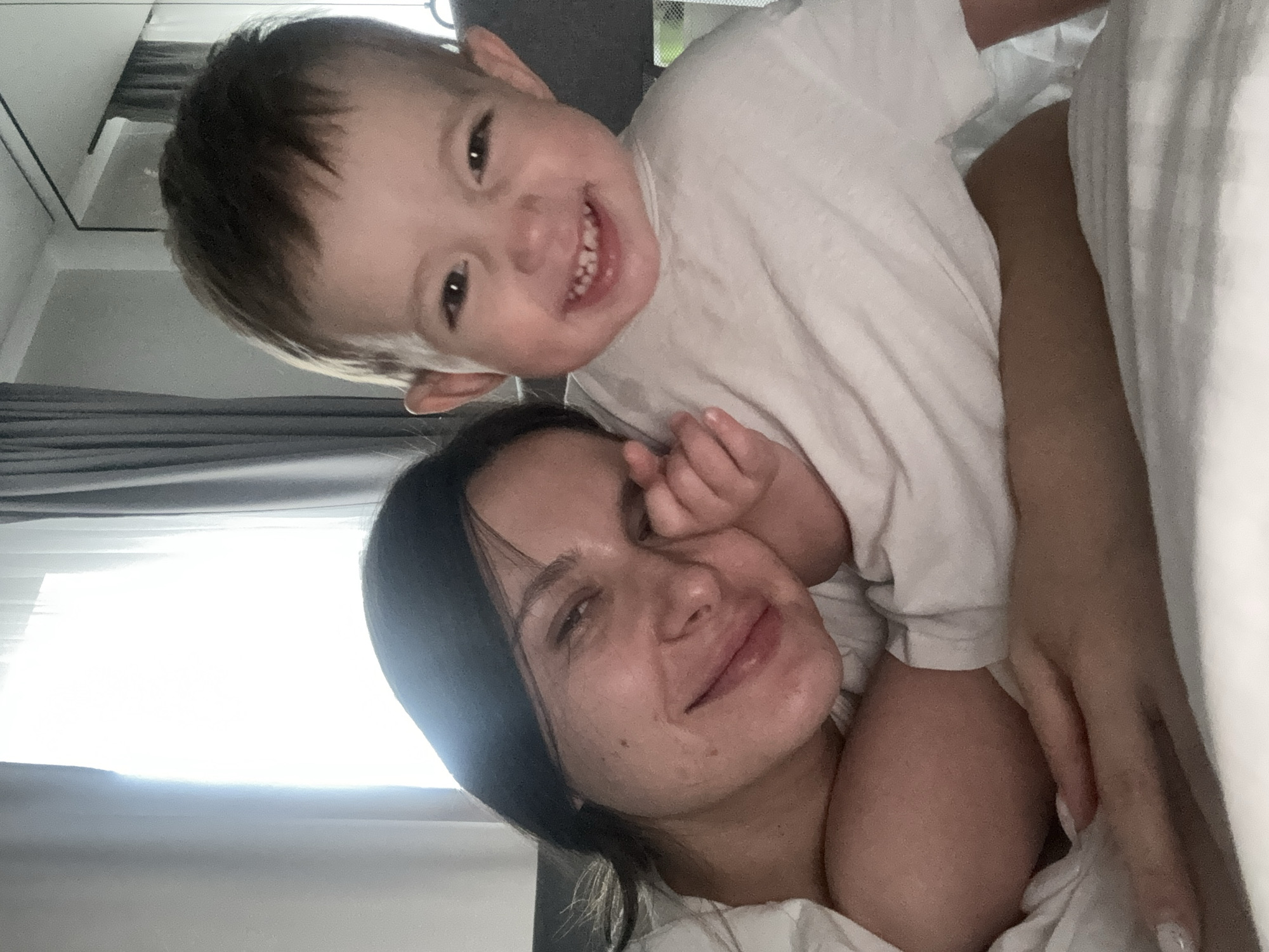 Woman and smiling child photographed together indoors