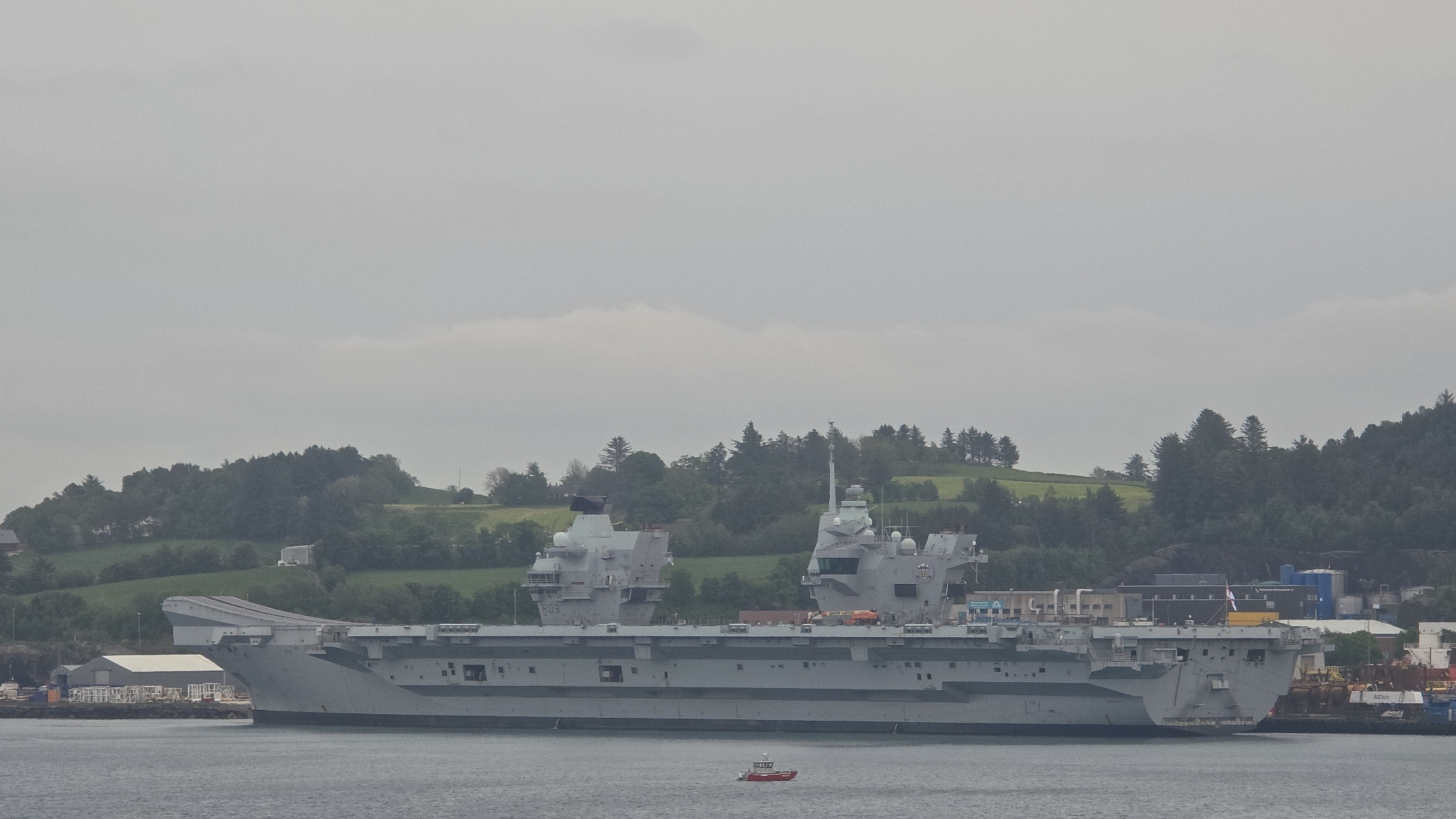 Naval vessels including aircraft carriers observed in harbor