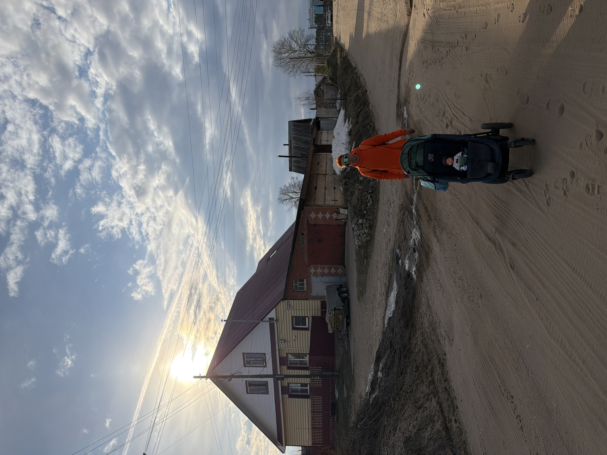 Parent pushes stroller through residential Chaikovsky neighborhood