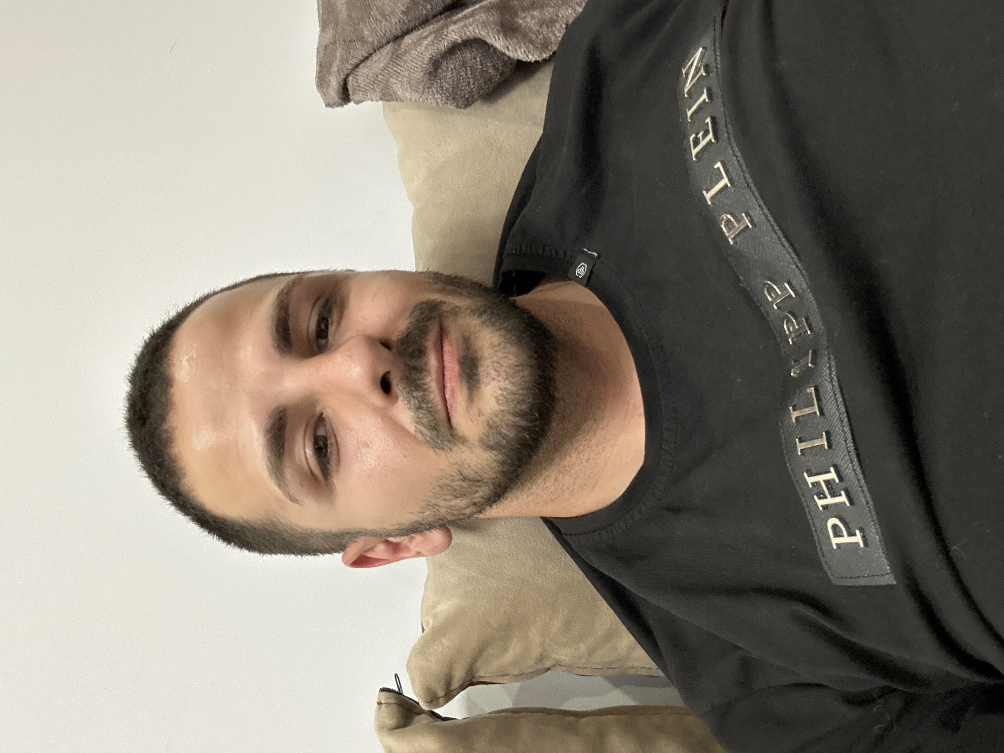 Man in designer shirt relaxes on beige cushions indoors