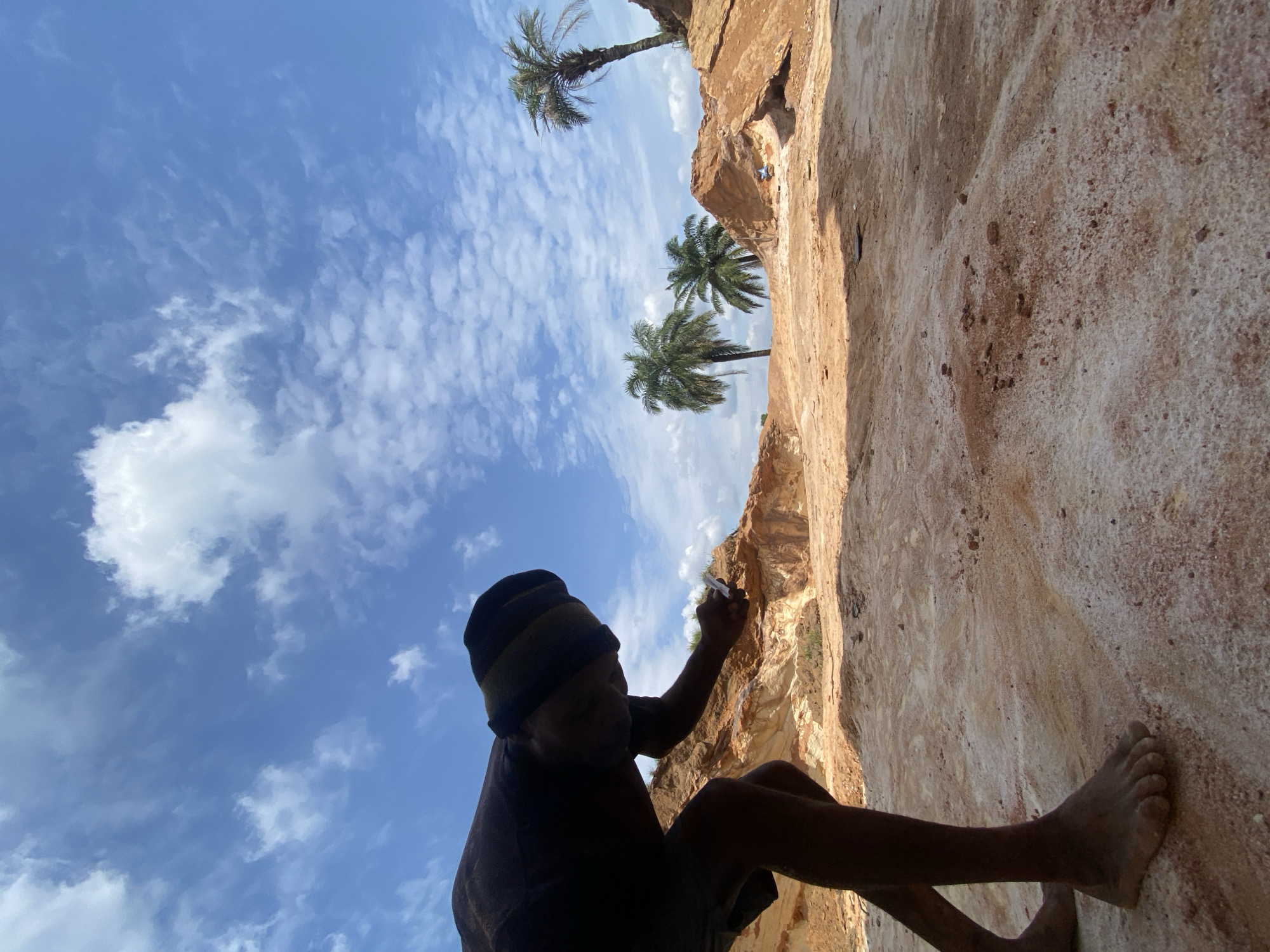 Barefoot climber scales rock face in Igbara, Nigeria