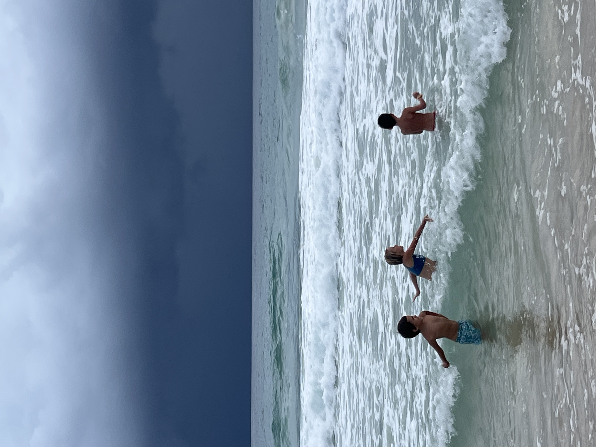 Stormy morning on a Choeng Thale beach, people still in the water
