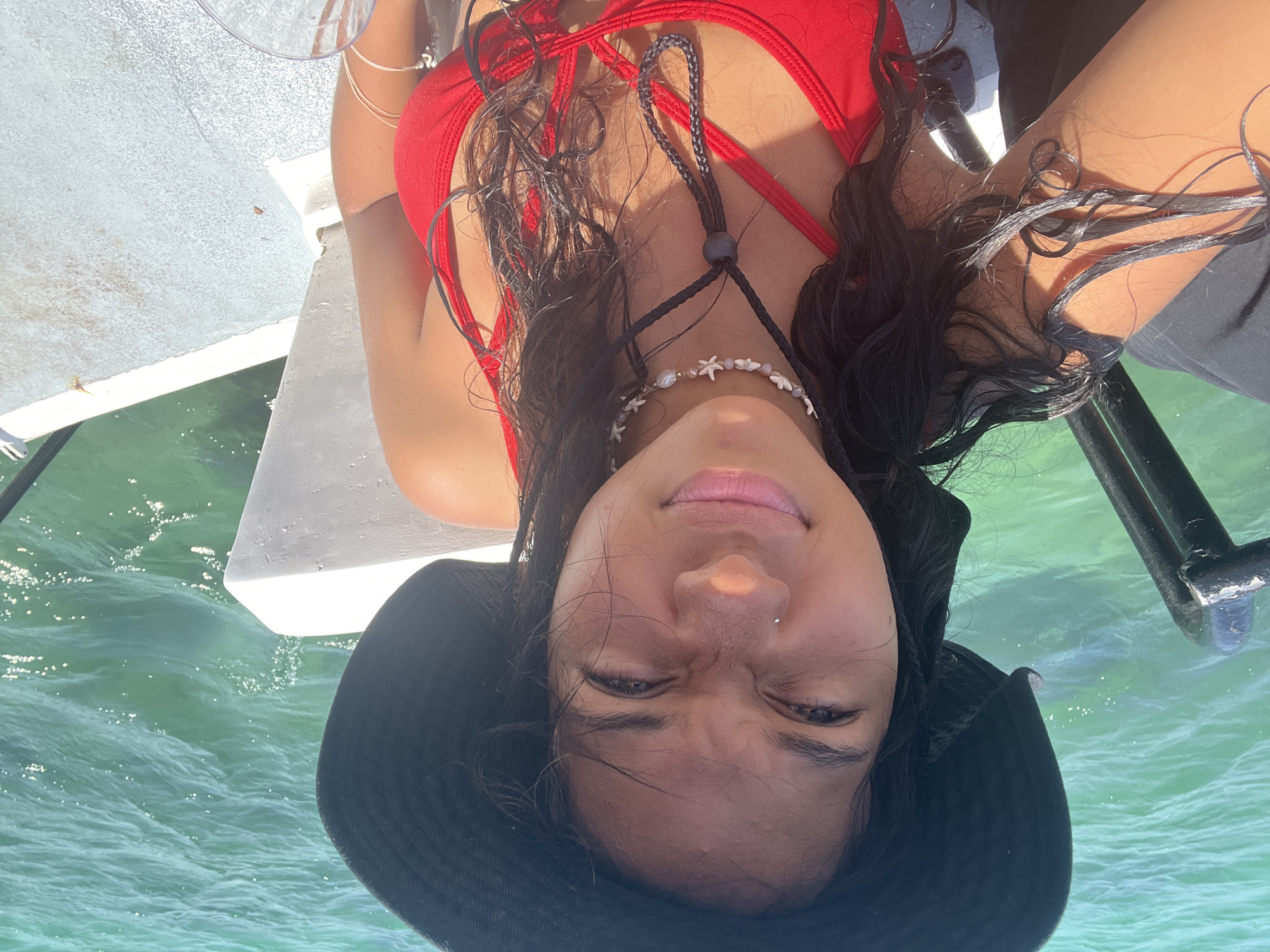 Woman in red swimsuit relaxes by turquoise water in Venezuela