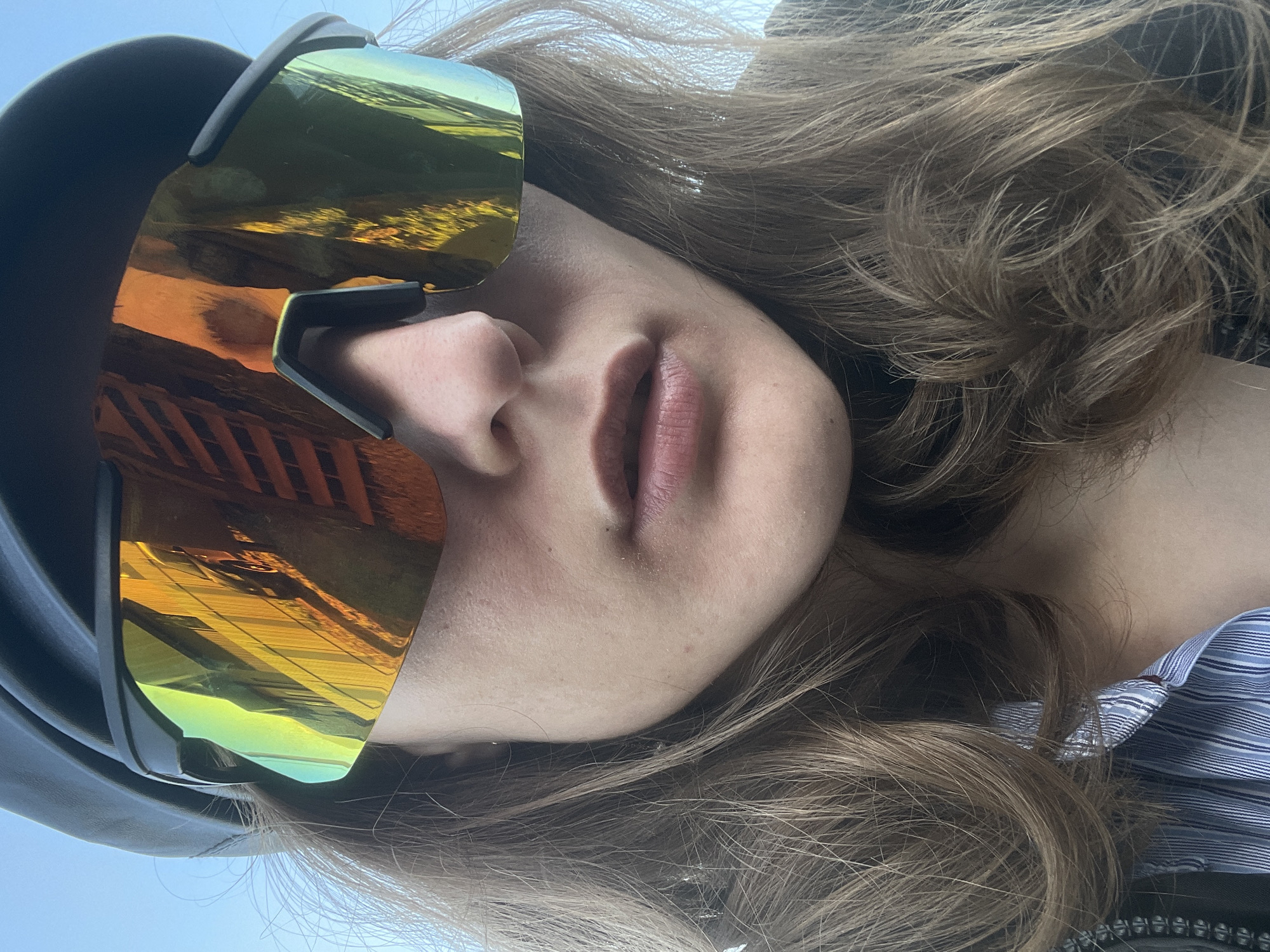 Person in gold sunglasses photographed at modern house in Russia