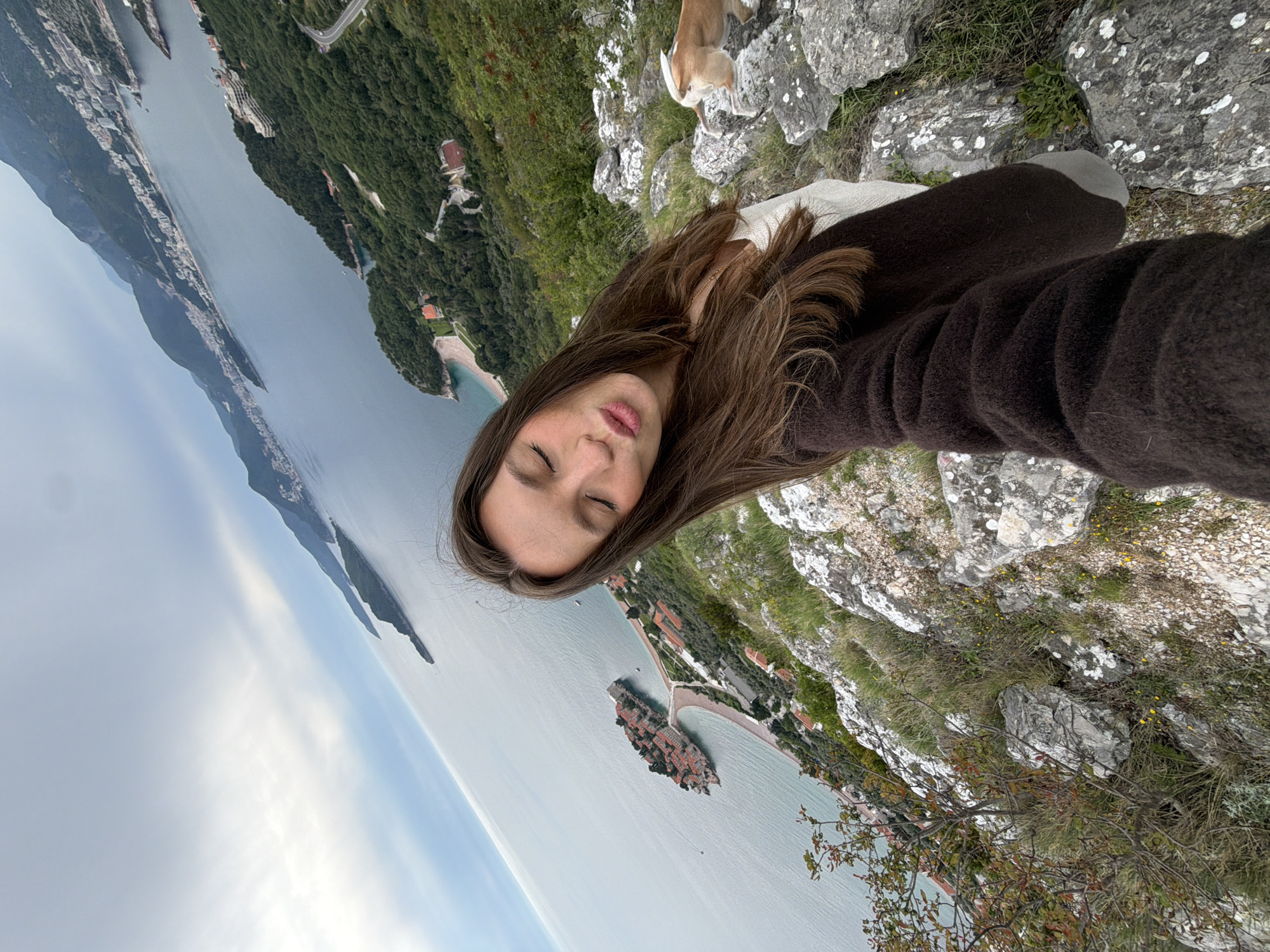 Woman takes selfie overlooking coastal Pržno, Montenegro