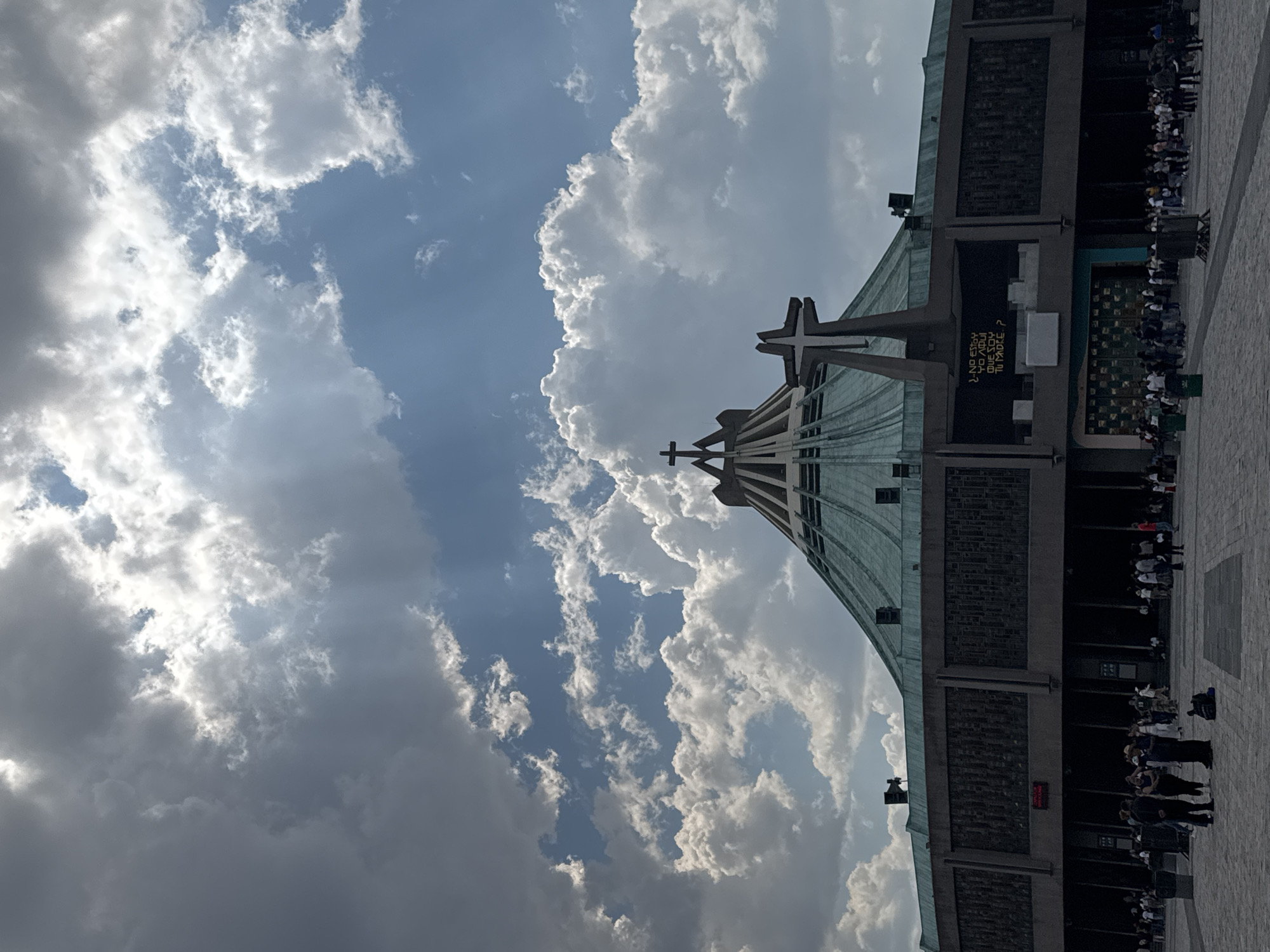 Evening gathering at modern basilica with distinctive architecture