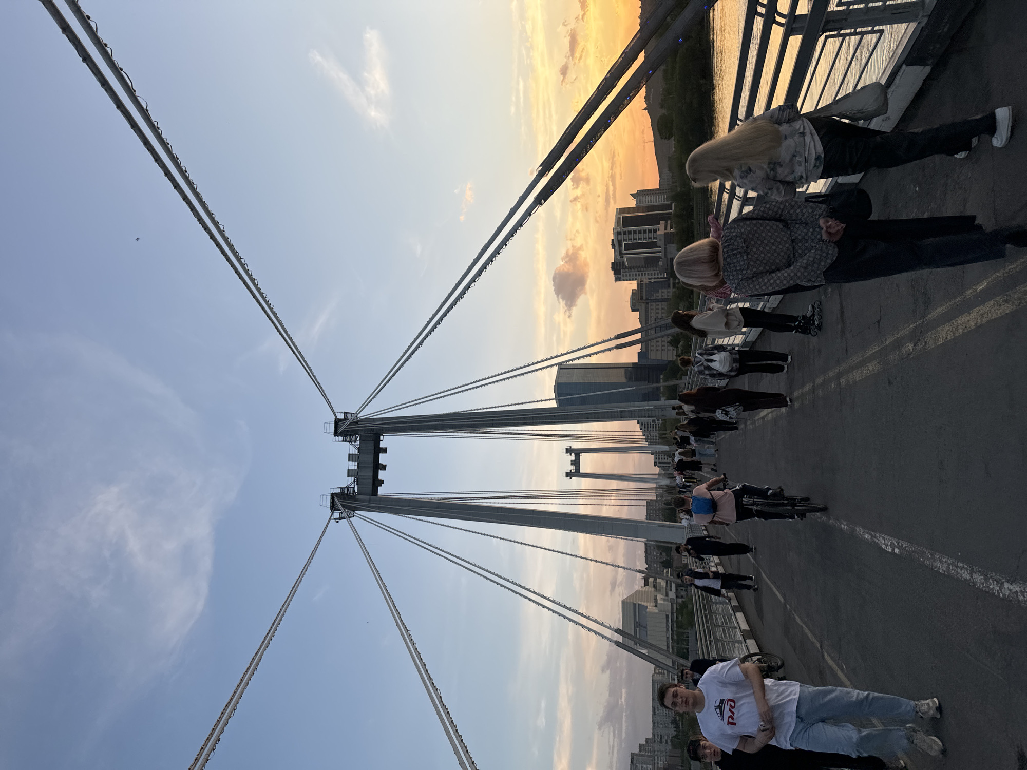 Rollerblader enjoys sunset near Krasnoyarsk bridge during golden hour