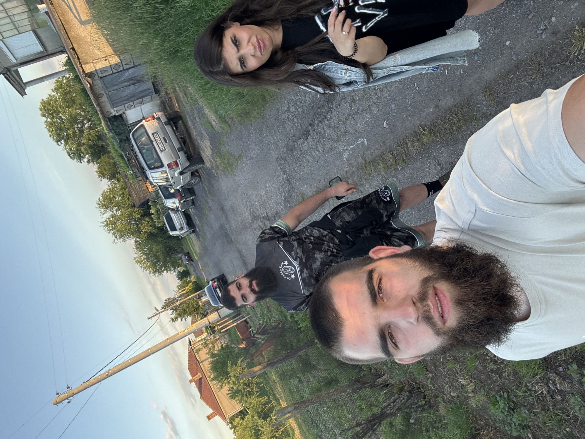 Three people gather on gravel road in Bulgarian village