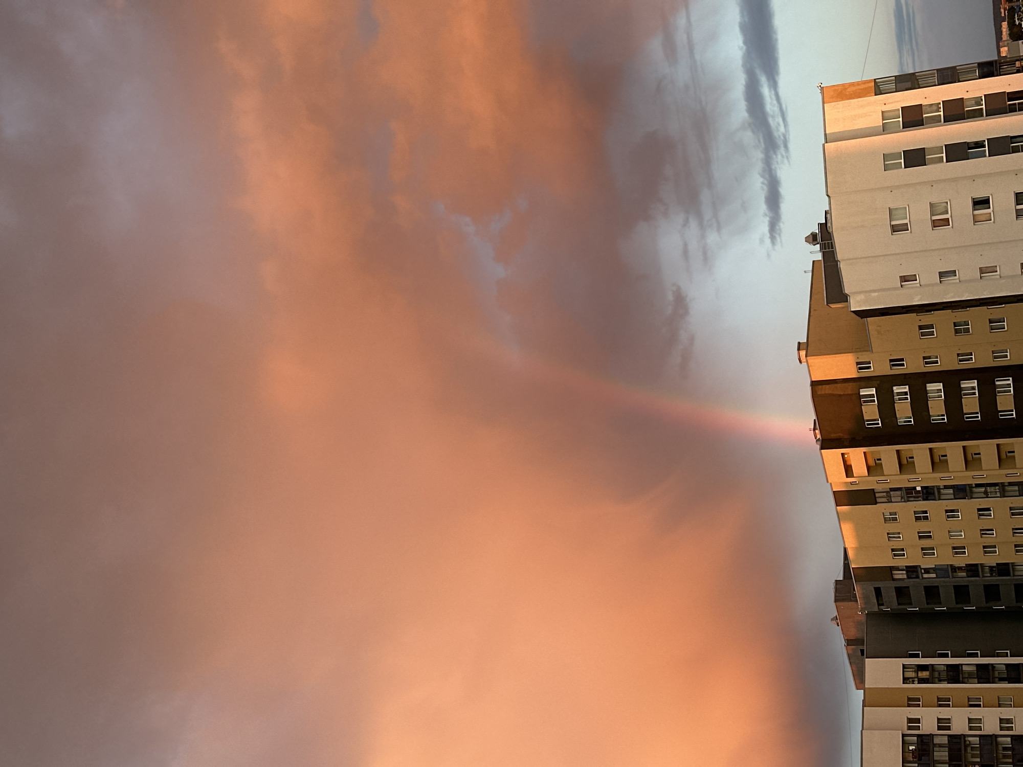 Rainbow arcs over Yekaterinburg cityscape during evening hours