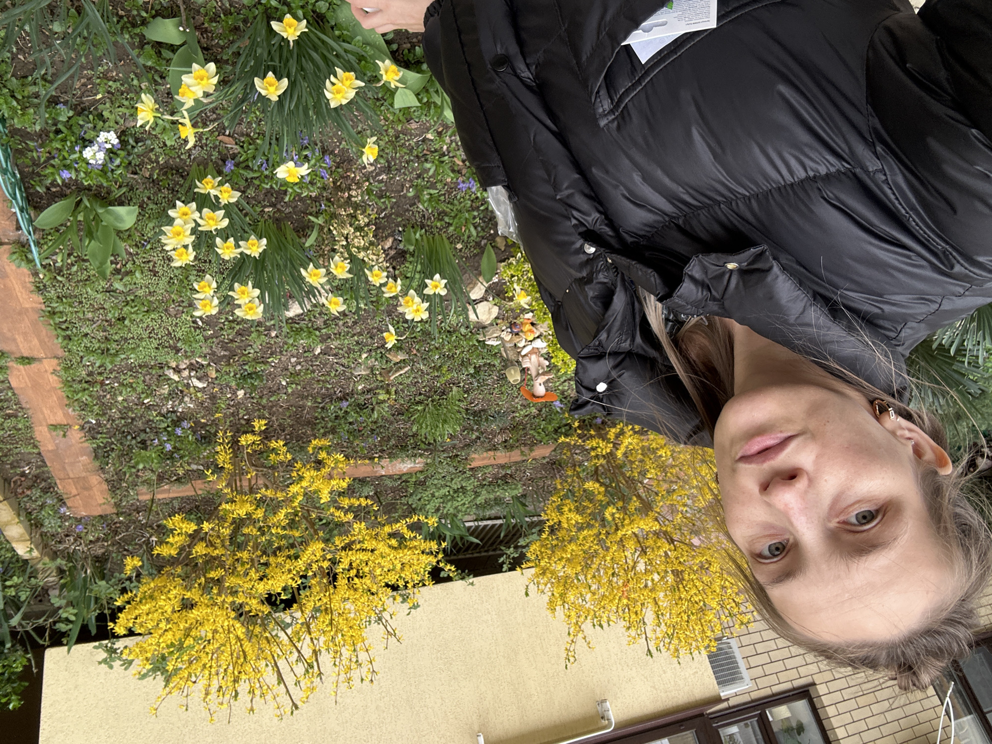 Woman enjoys spring blooms in Anapa garden