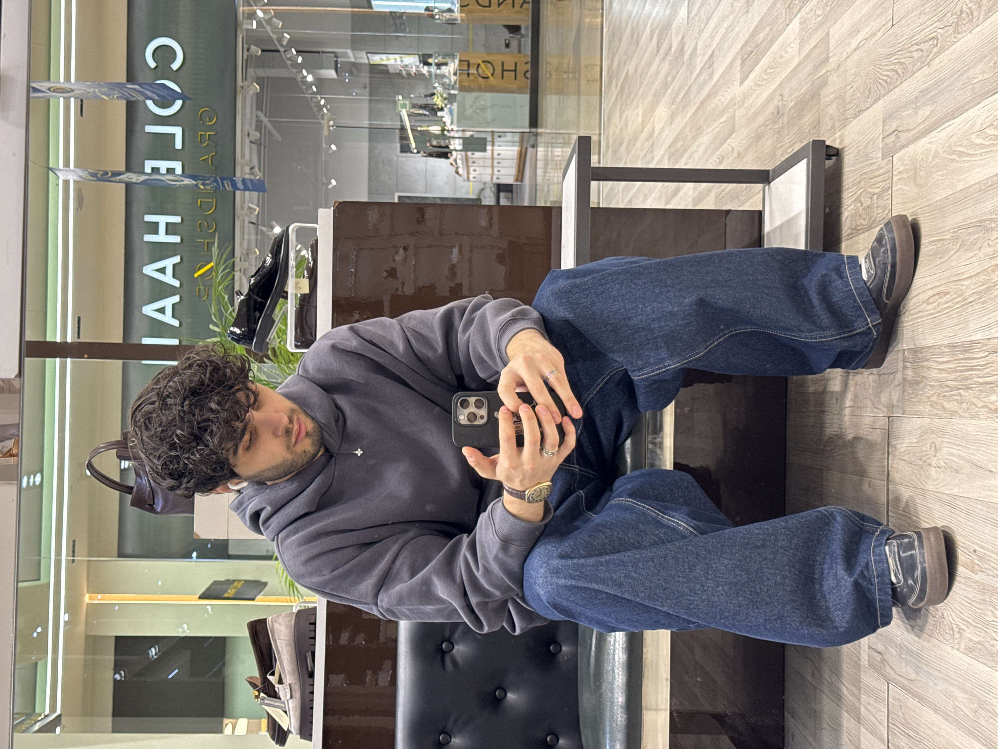 Young man sits on bench in Yerevan retail store
