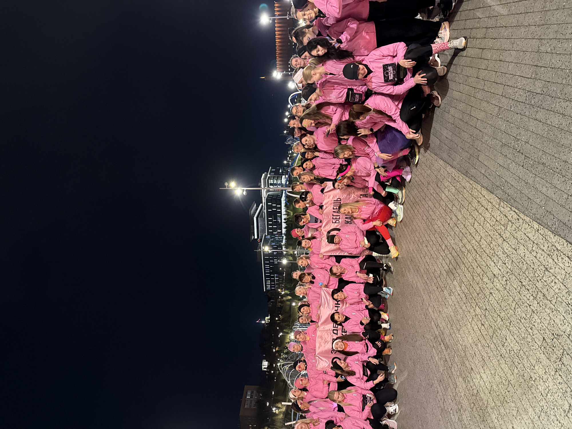 Pink-clad group poses with Cyrillic banner in Kazan