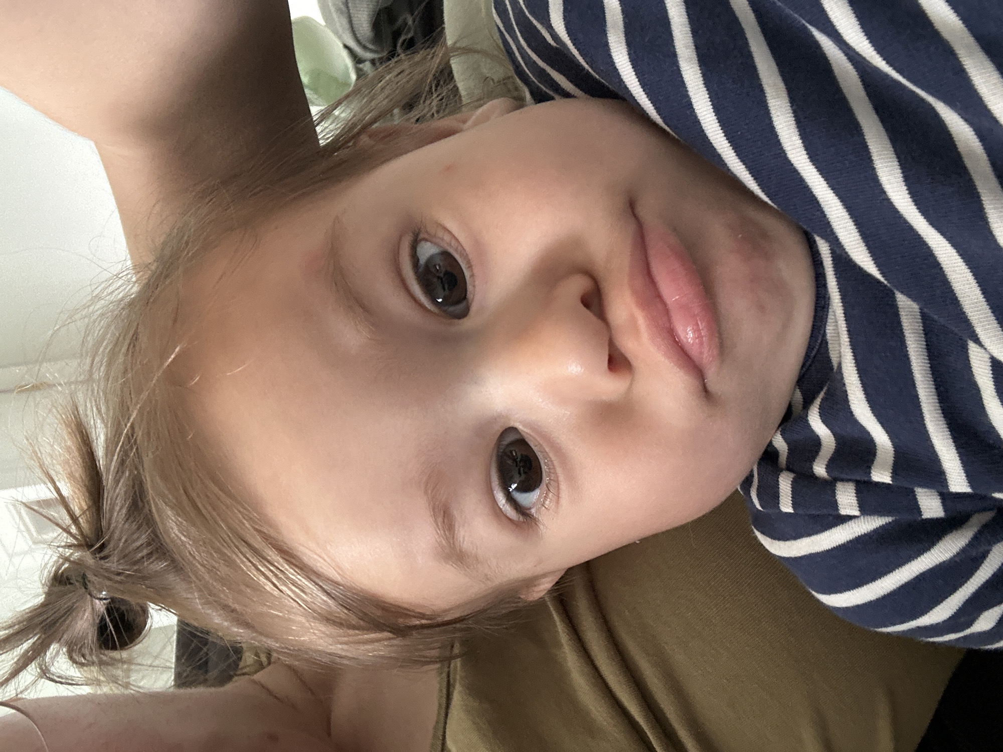 Mother and toddler share quiet morning moment on couch