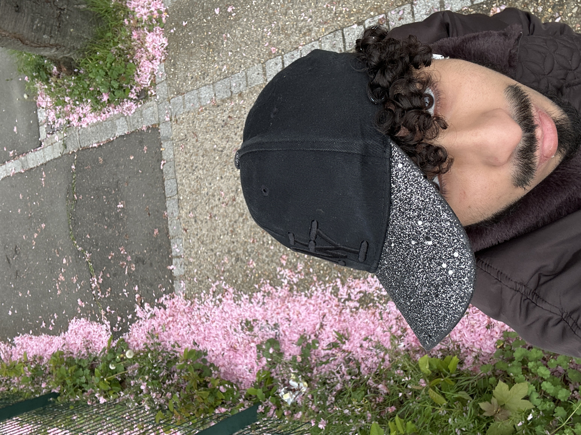 Person collects fallen cherry blossom petals in Orsay, France